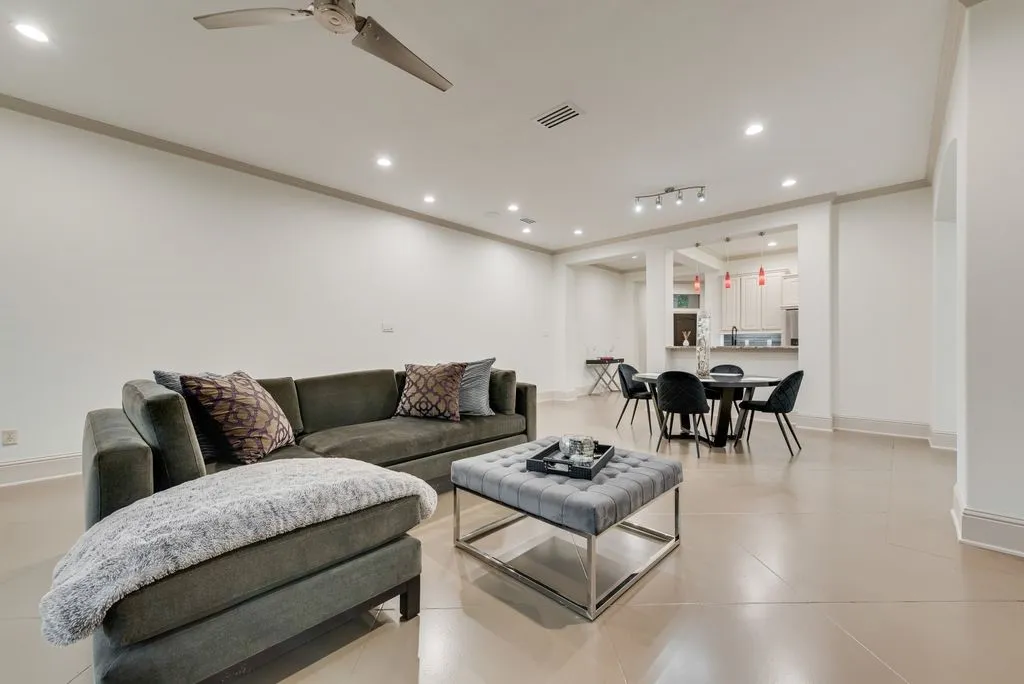 Open-concept living area with light-toned flooring and recessed lighting