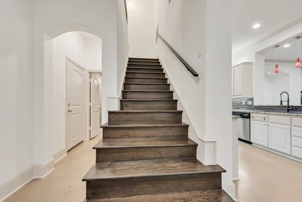 Hardwood staircase featuring a dark wood finish and sleek handrail