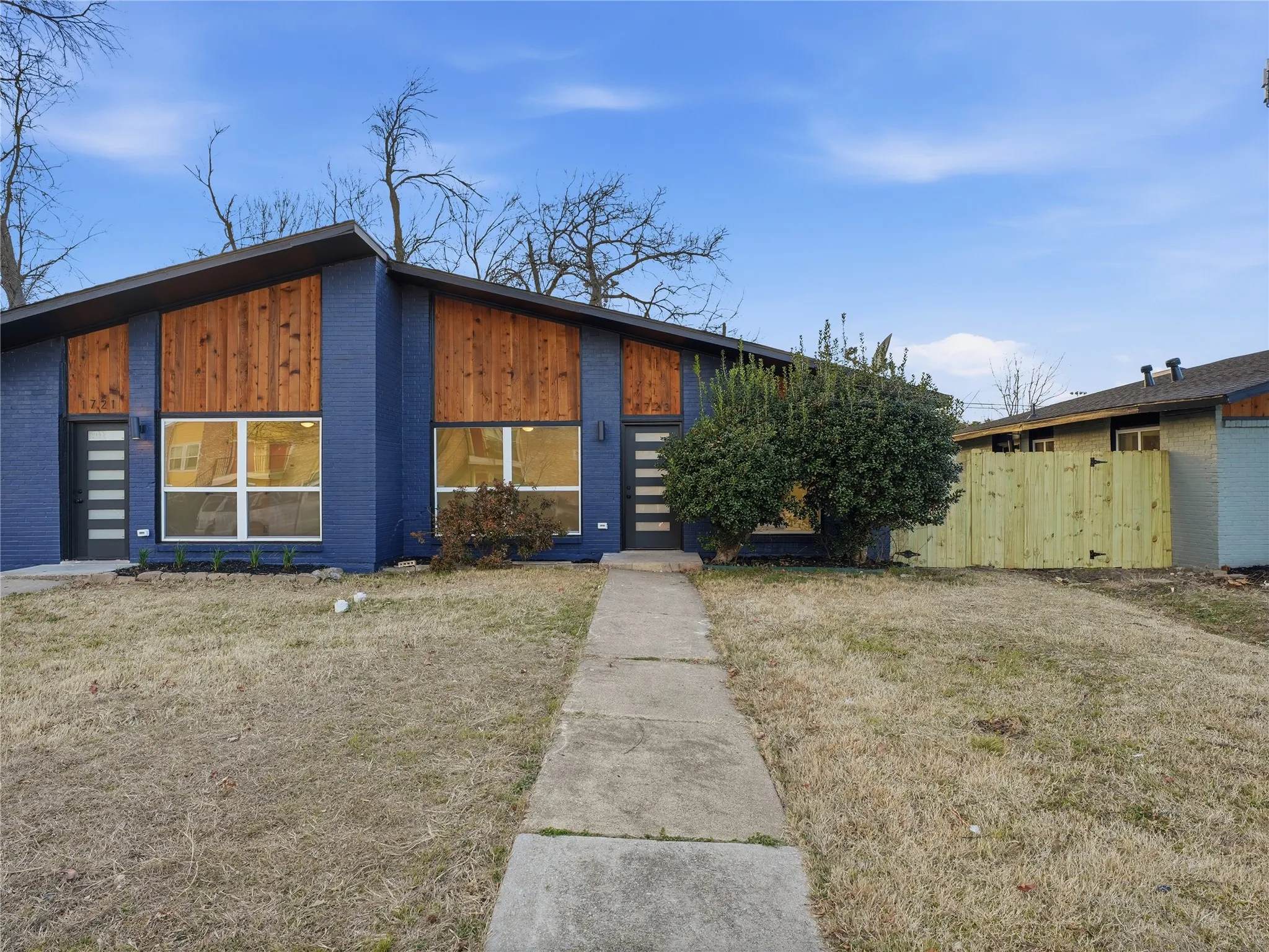 Contemporary blue brick facade with warm wood-paneled accents