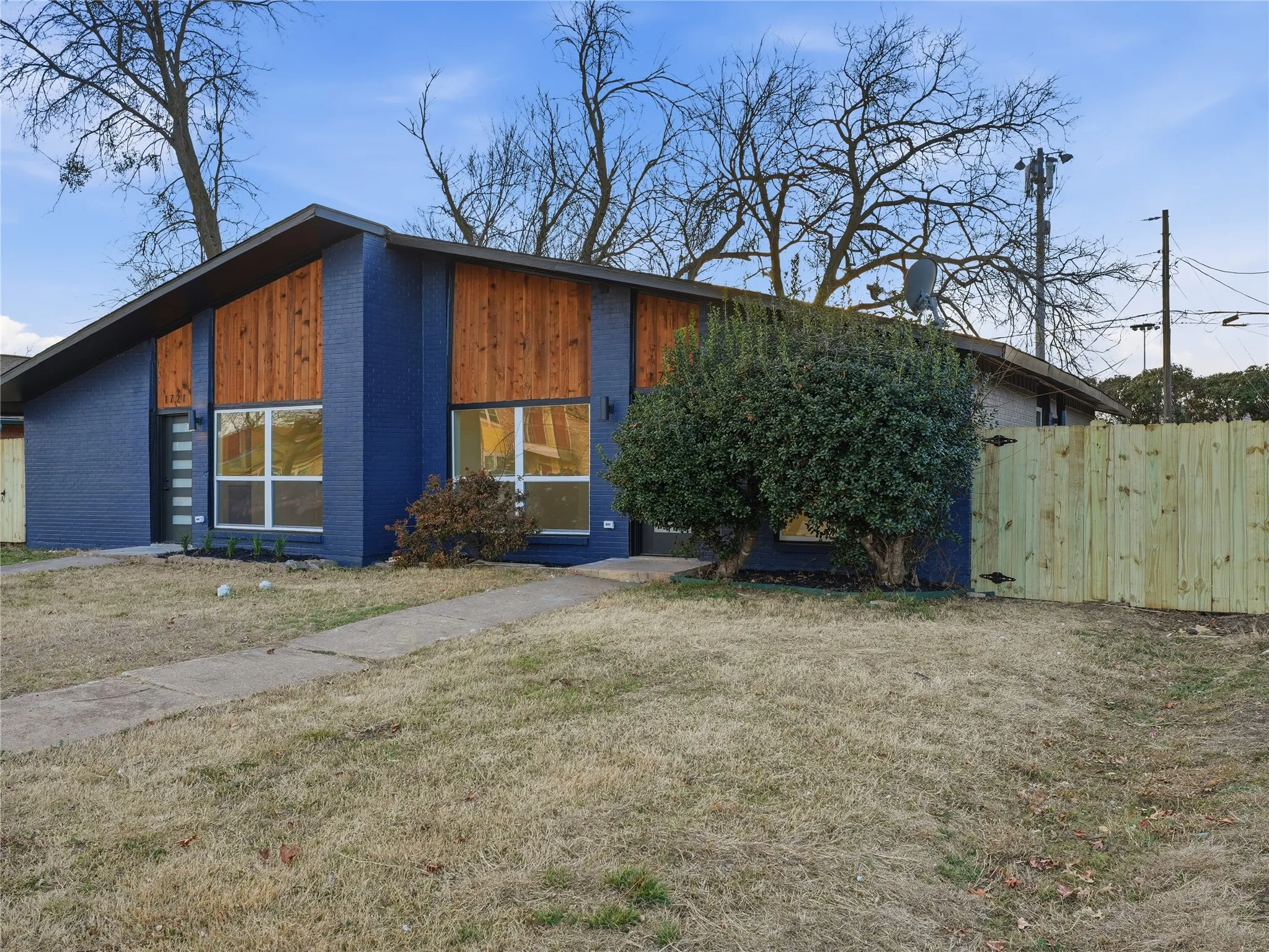 Contemporary facade featuring blue brick and natural wood-finish siding accents