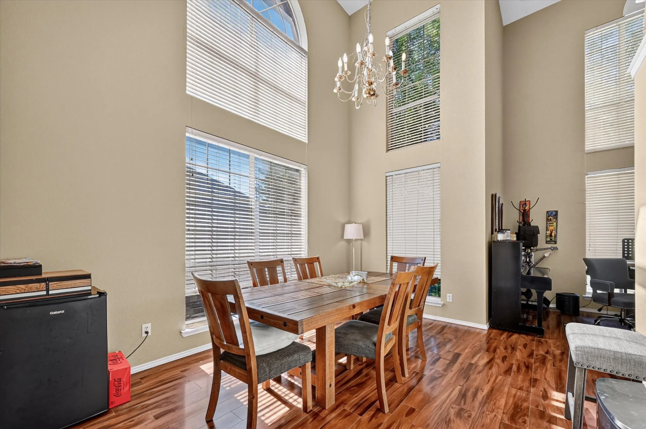 Expansive room featuring high ceilings and wood-finish flooring