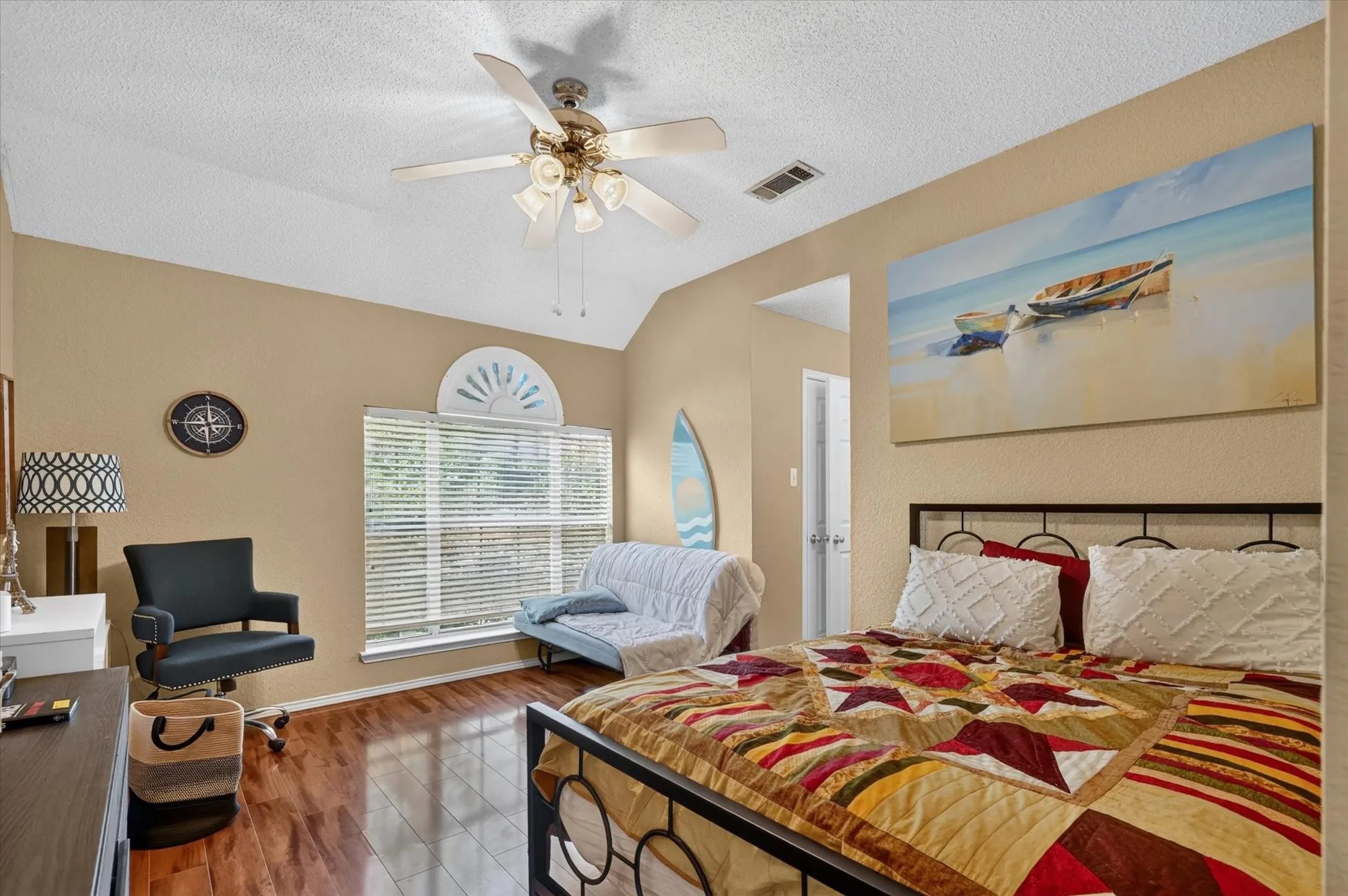 Vaulted ceiling with a ceiling fan, wood-finish flooring, and a window with blinds and an arched transom