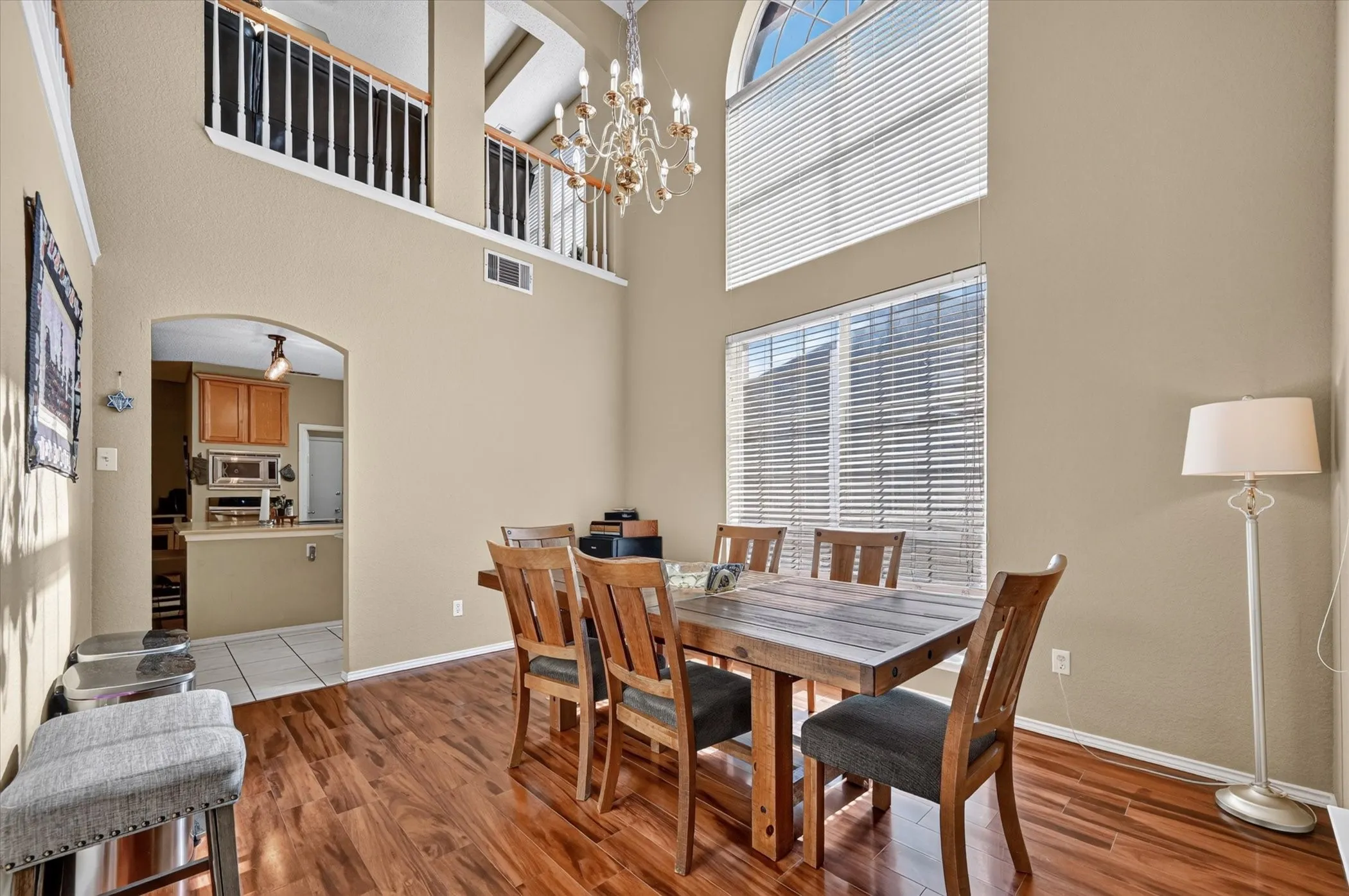 Two-story dining space featuring wood-finish flooring and a high vaulted ceiling