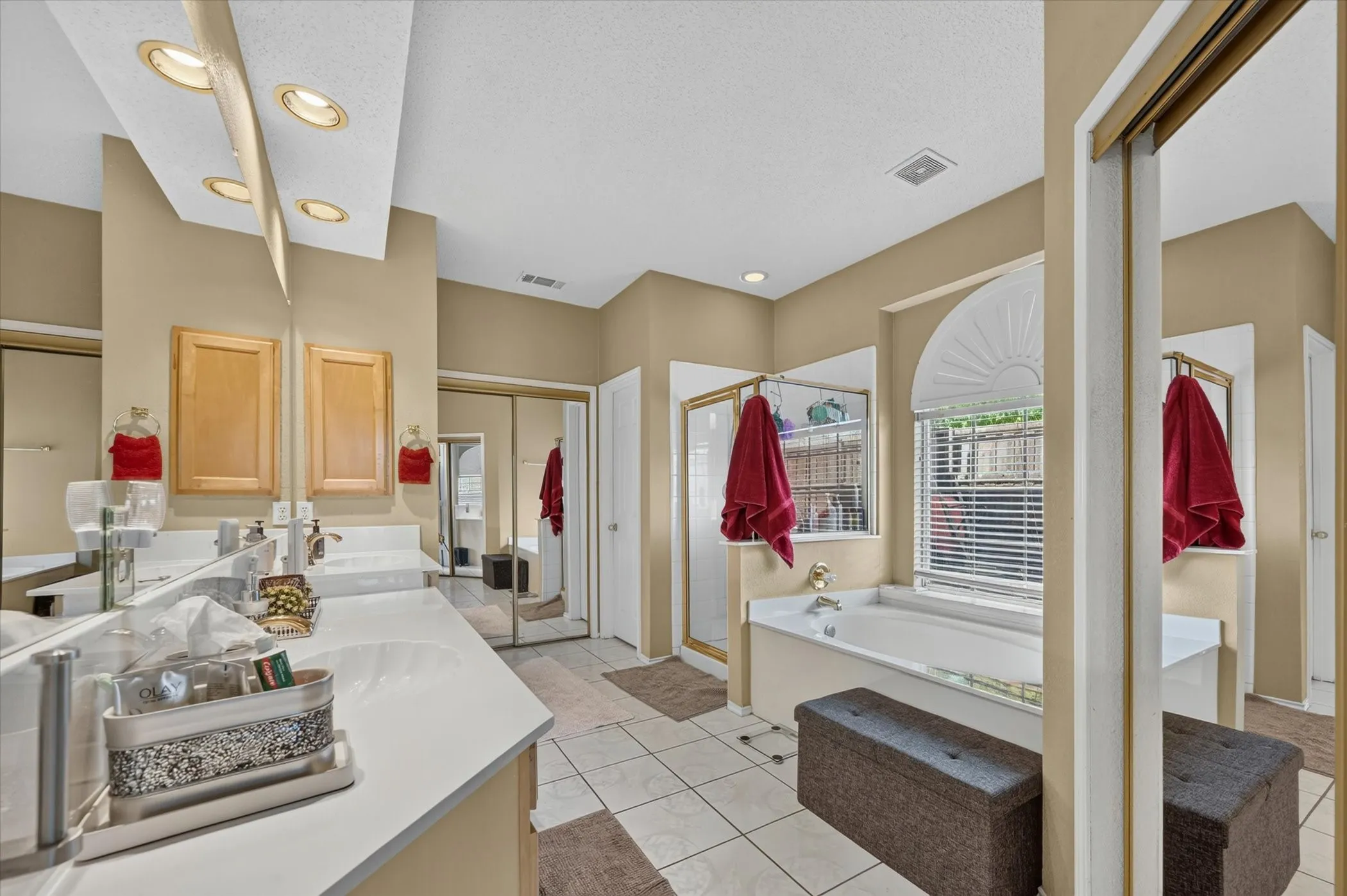 Dual vanity with white countertops, integrated sinks, and overhead recessed lighting