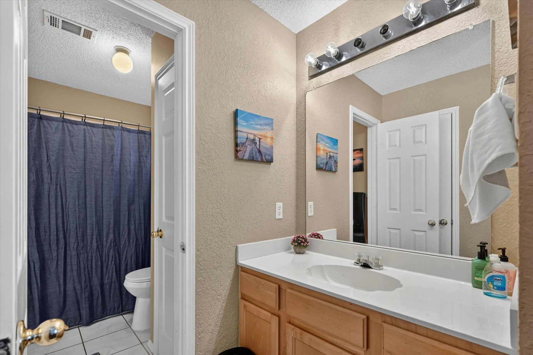 Bathroom featuring a light wood-finish vanity with a white countertop and integrated sink
