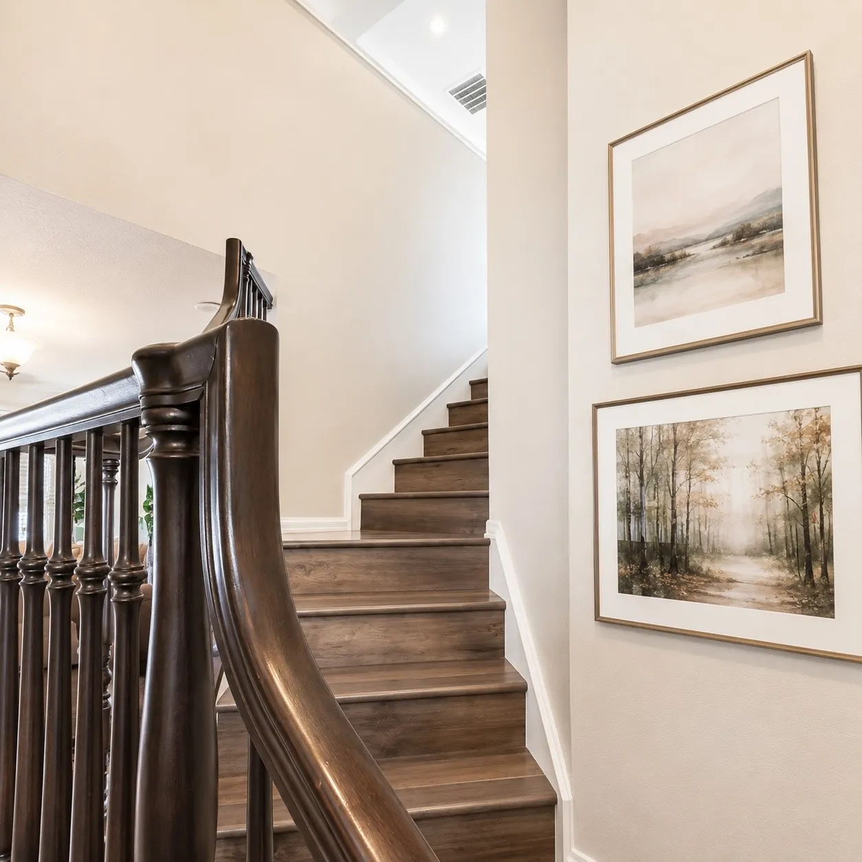 Curved dark wood staircase with wood-finish treads and white risers