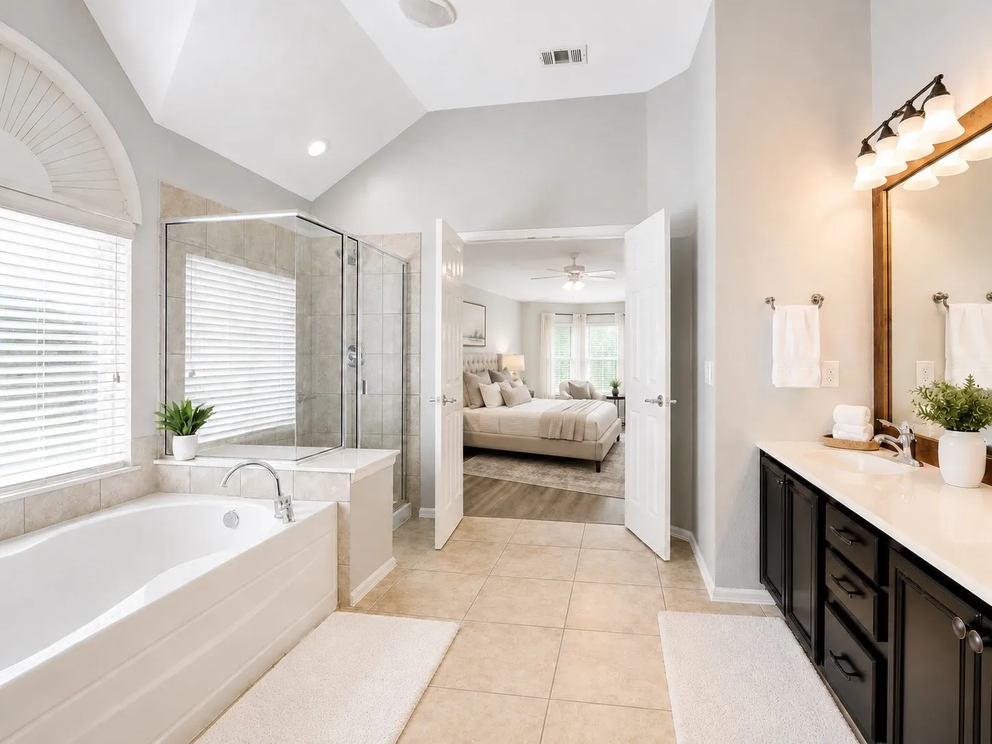 Spacious bathroom featuring a dual vanity with dark wood cabinetry, a large soaking tub, and a glass-enclosed walk-in shower