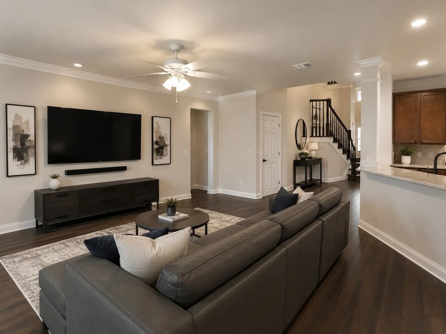 Open-concept living space featuring wood-finish flooring and crown molding