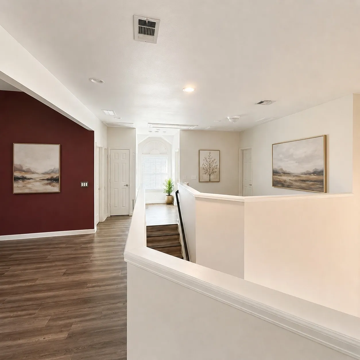 Upper-level hallway featuring wood-finish flooring, recessed lighting, and a decorative wall accent