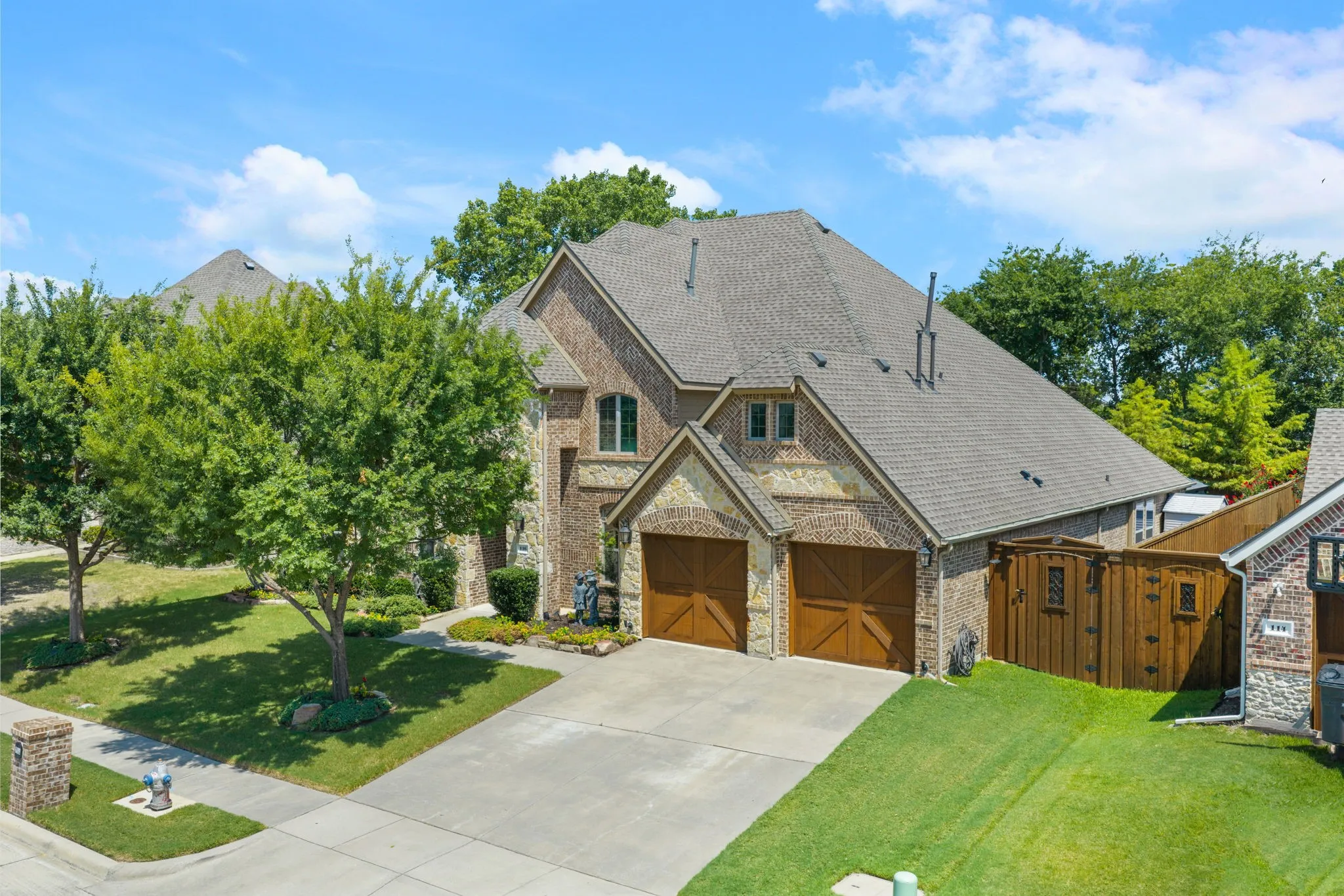 Two-story brick and stone facade with a shingle roof and multiple gables