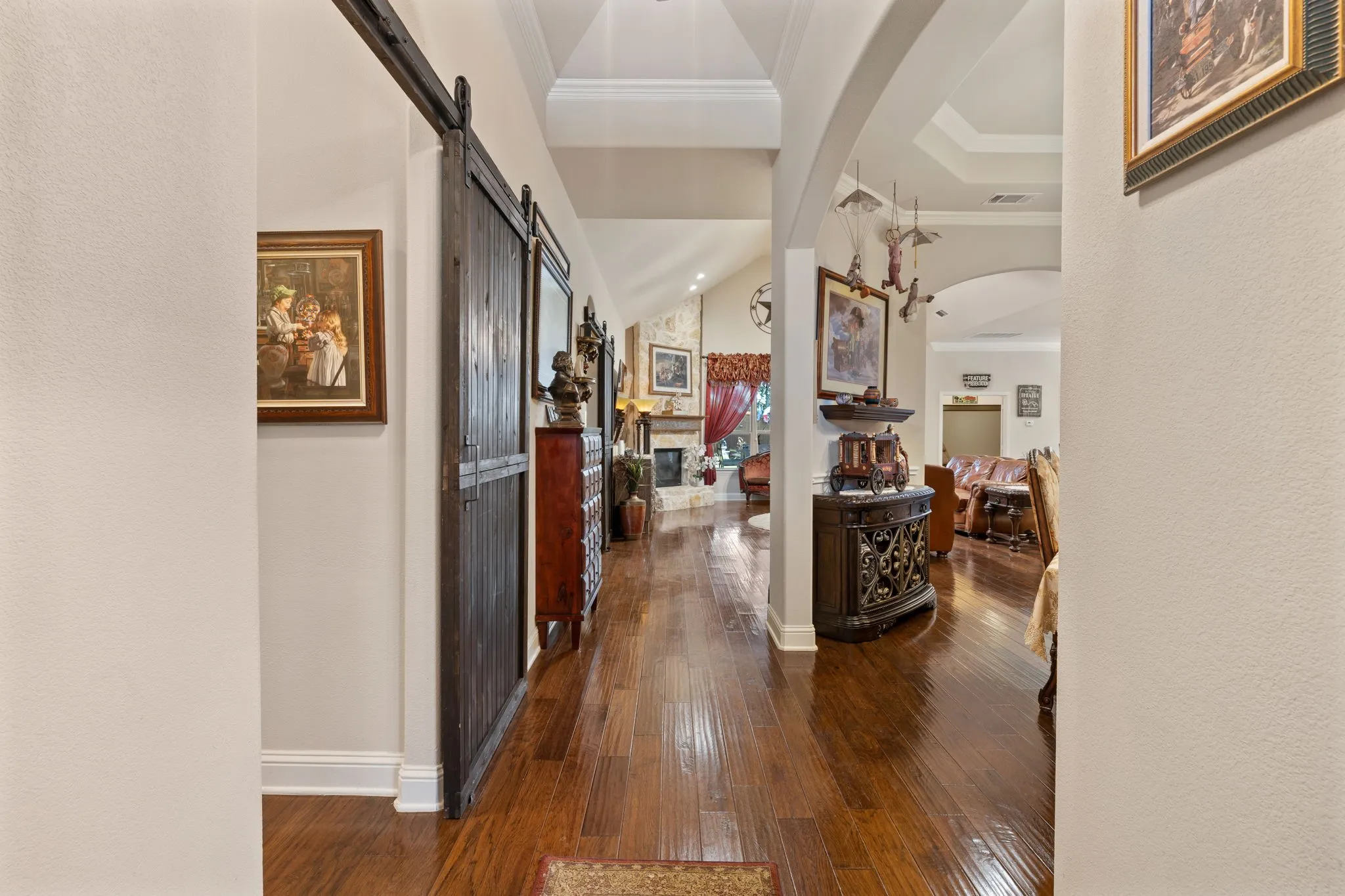 Rich wood-finish flooring extending through an arched entryway