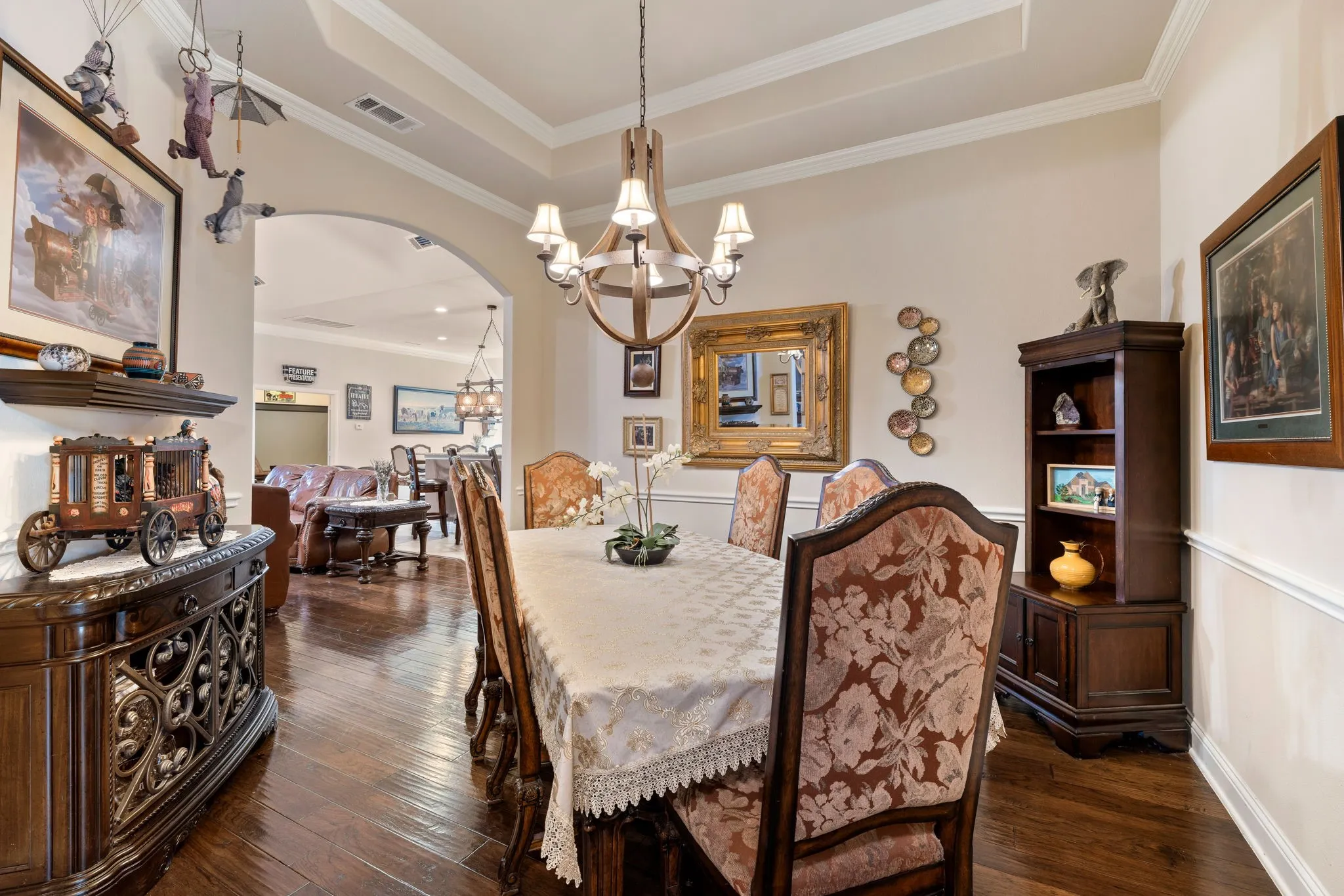 Formal dining area featuring hardwood flooring, a coffered ceiling, crown molding, and wainscoting