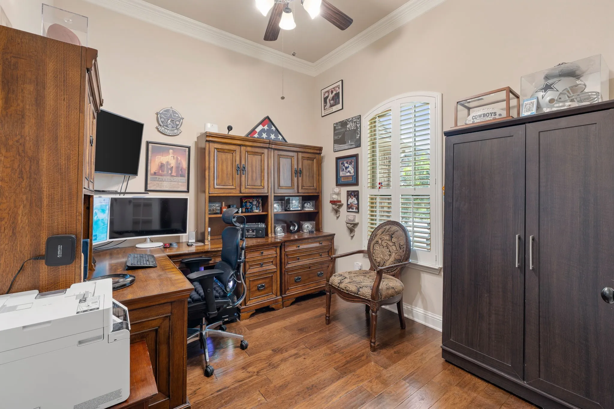 Room featuring wood-finish flooring, a ceiling fan with integrated lighting, and crown molding