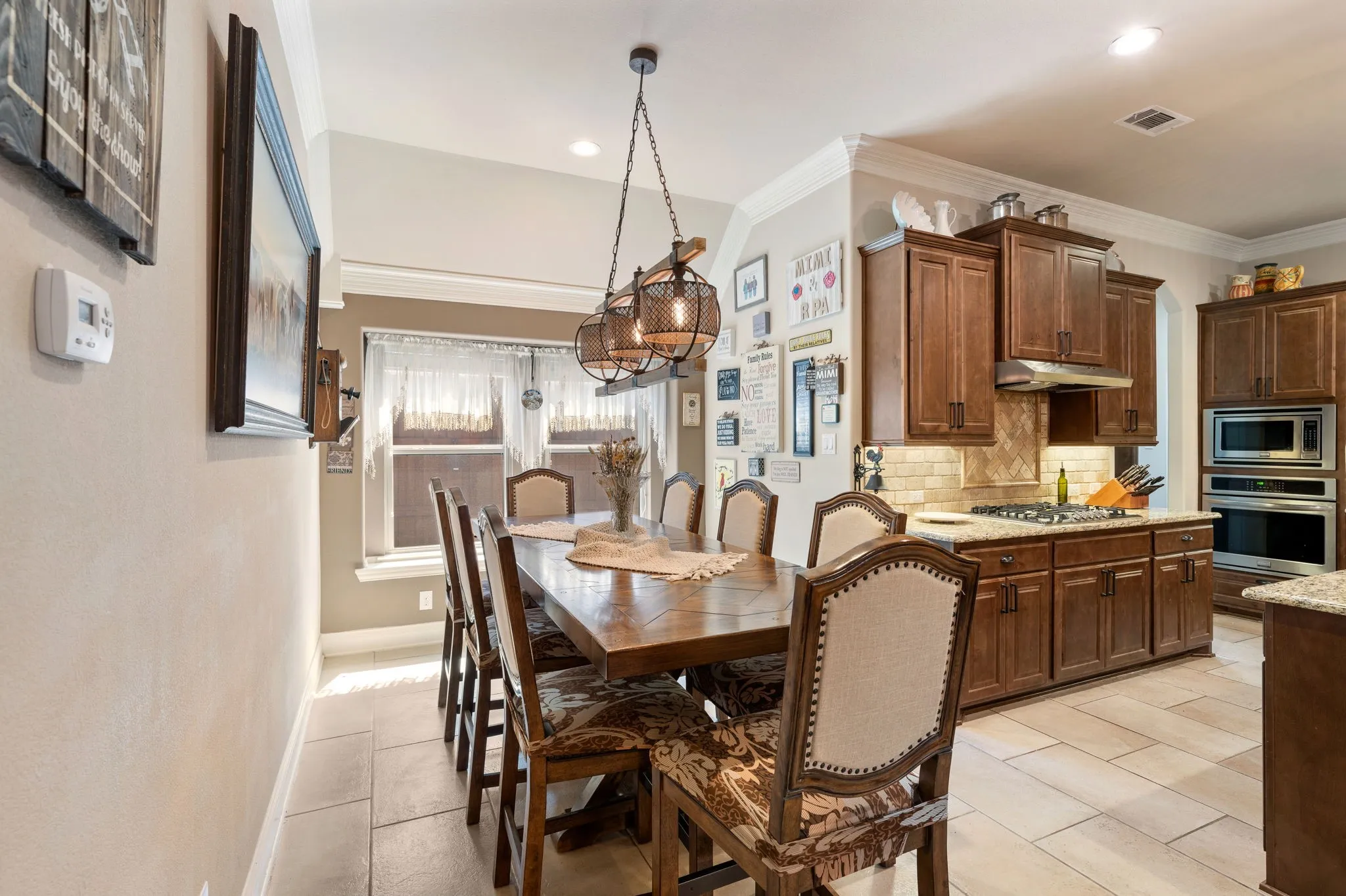 Kitchen and dining area featuring wood-finish cabinetry and light-toned tile flooring