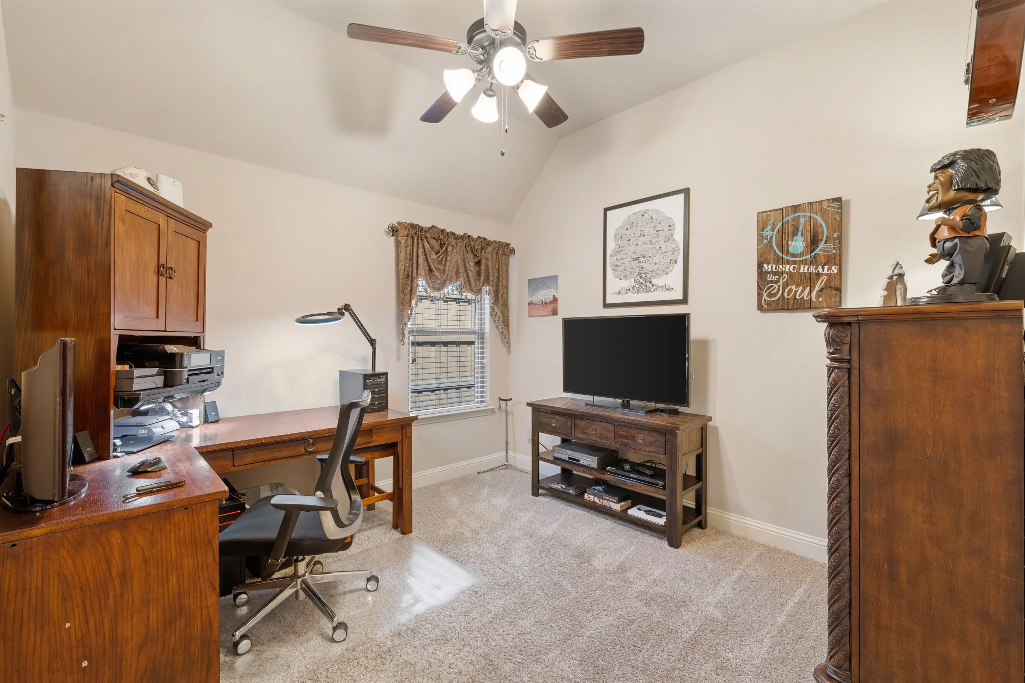 Secondary bedroom. Carpeted room featuring a vaulted ceiling and a ceiling fan with light fixture
