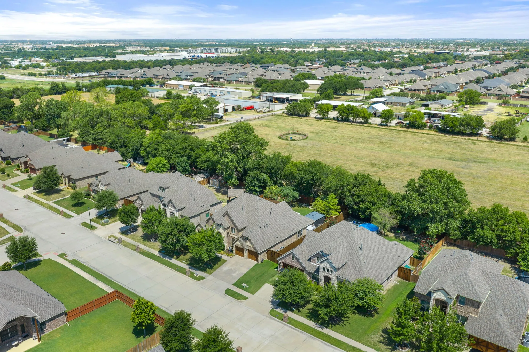 Aerial perspective showcasing a residential street with uniform detached homes, each featuring gabled roofs and individual landscaping