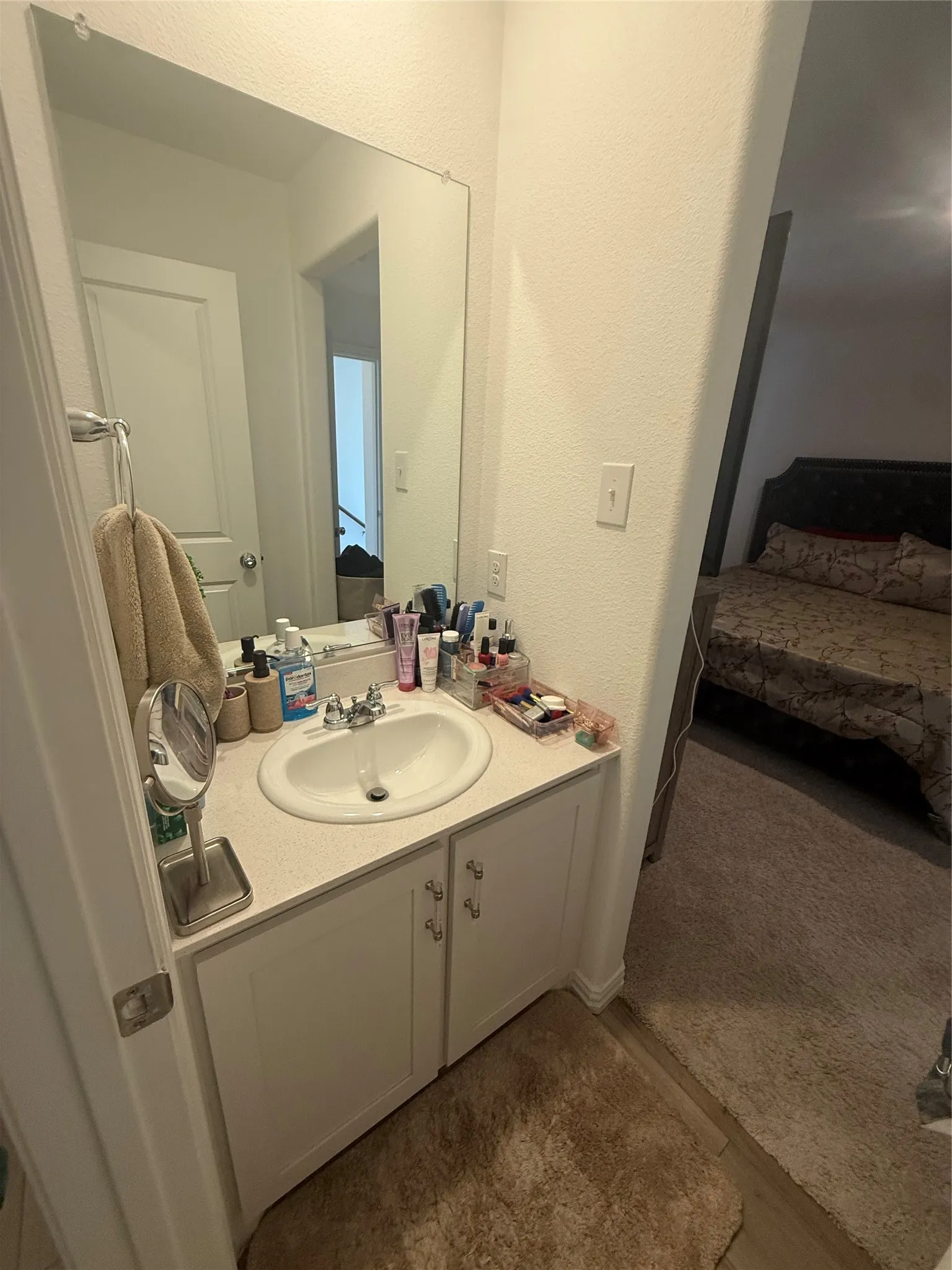 Bathroom vanity featuring a white oval sink, chrome faucet, and ample countertop space