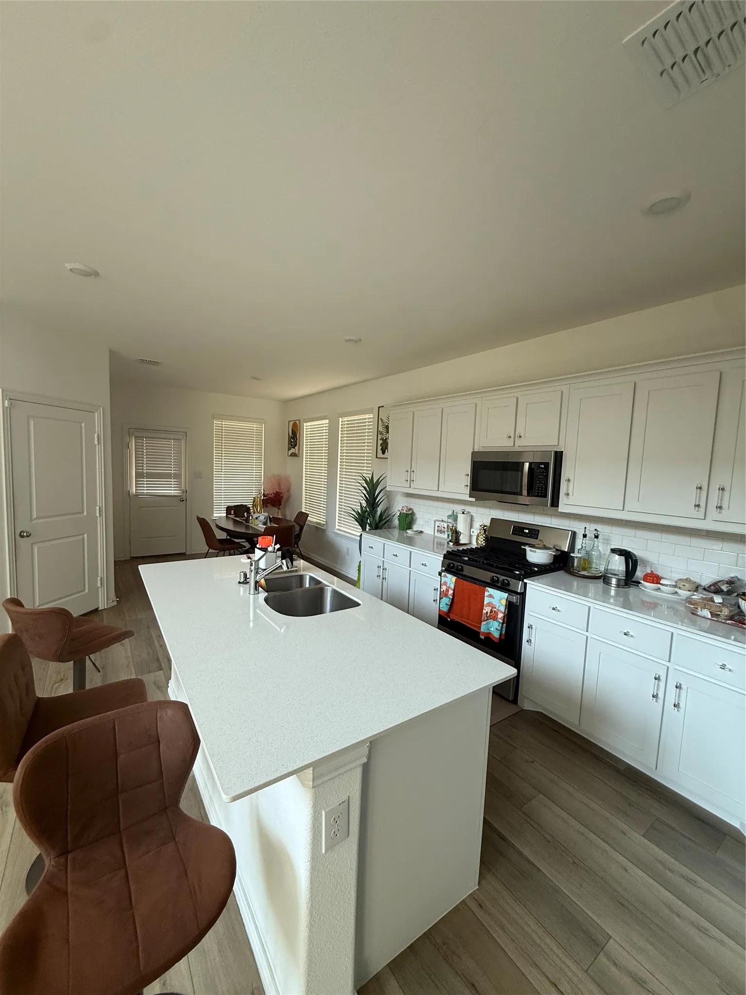 Expansive kitchen island with a double basin stainless steel sink and white countertop