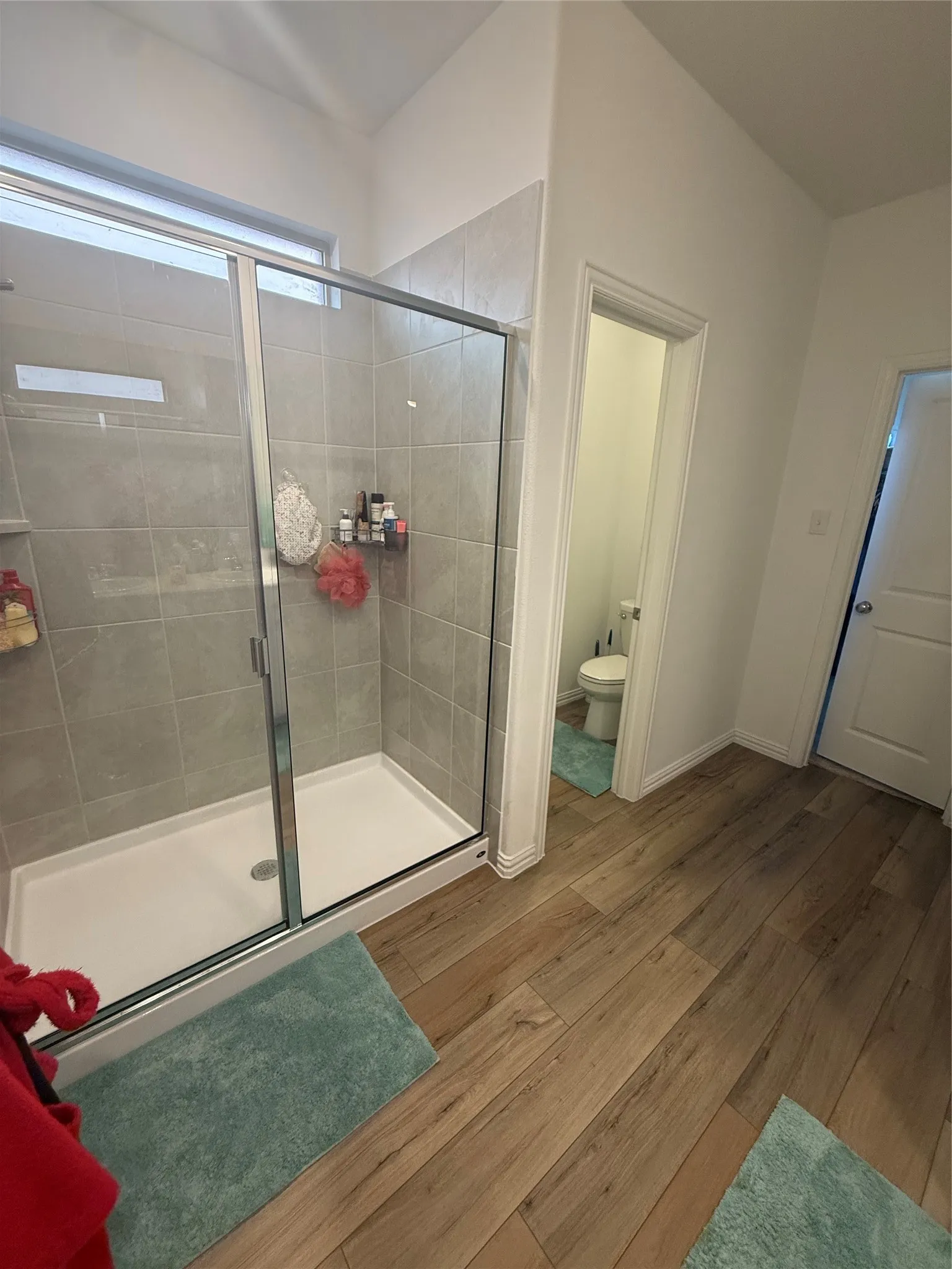 Contemporary shower enclosure featuring clear glass and a light gray tile surround