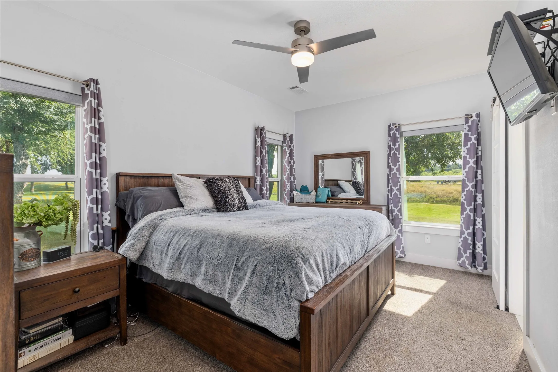 Carpeted bedroom featuring a vaulted ceiling and a ceiling fan with integrated lighting