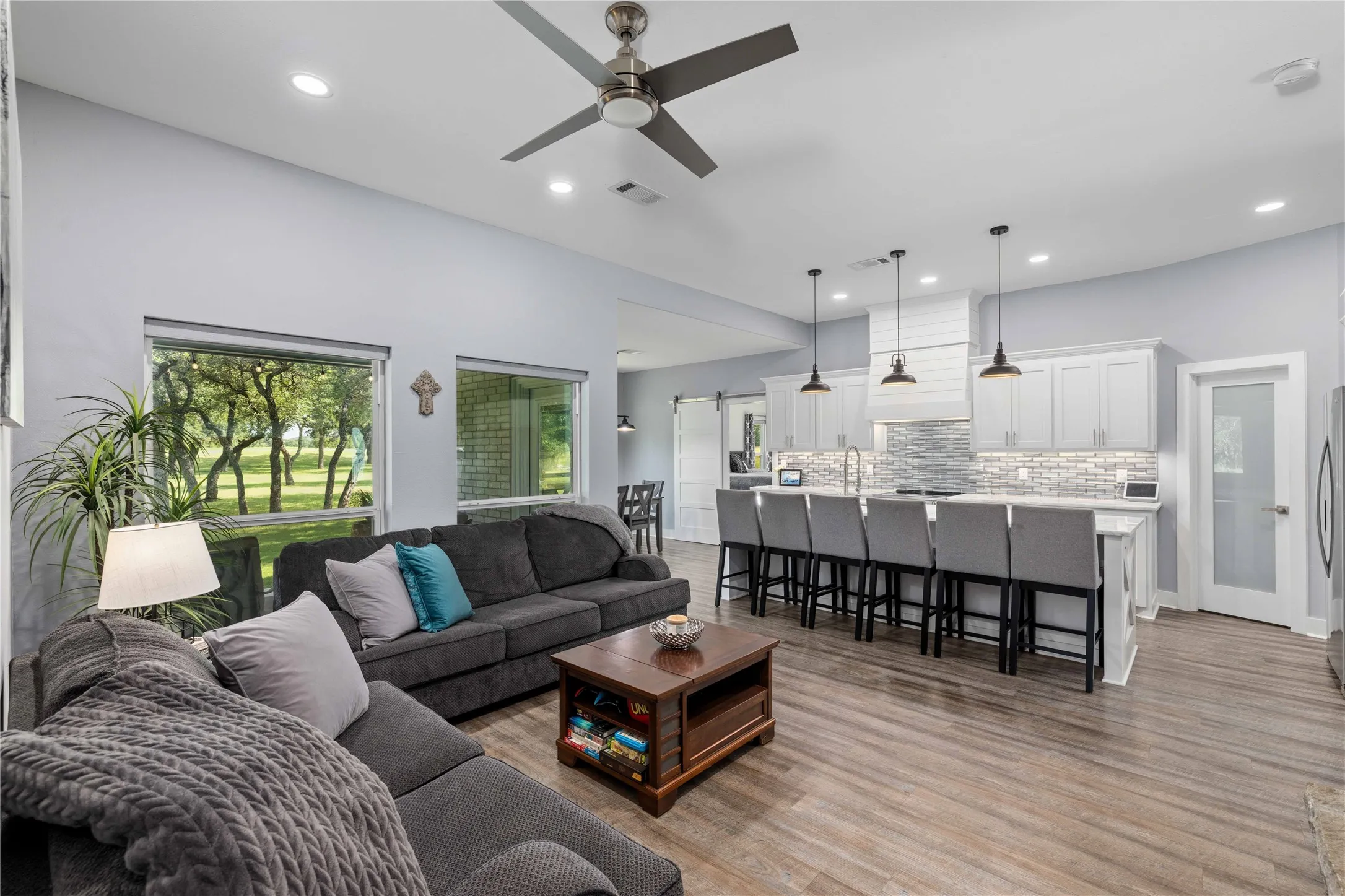 Open-concept living area featuring wood-finish flooring, recessed lighting, and a ceiling fan