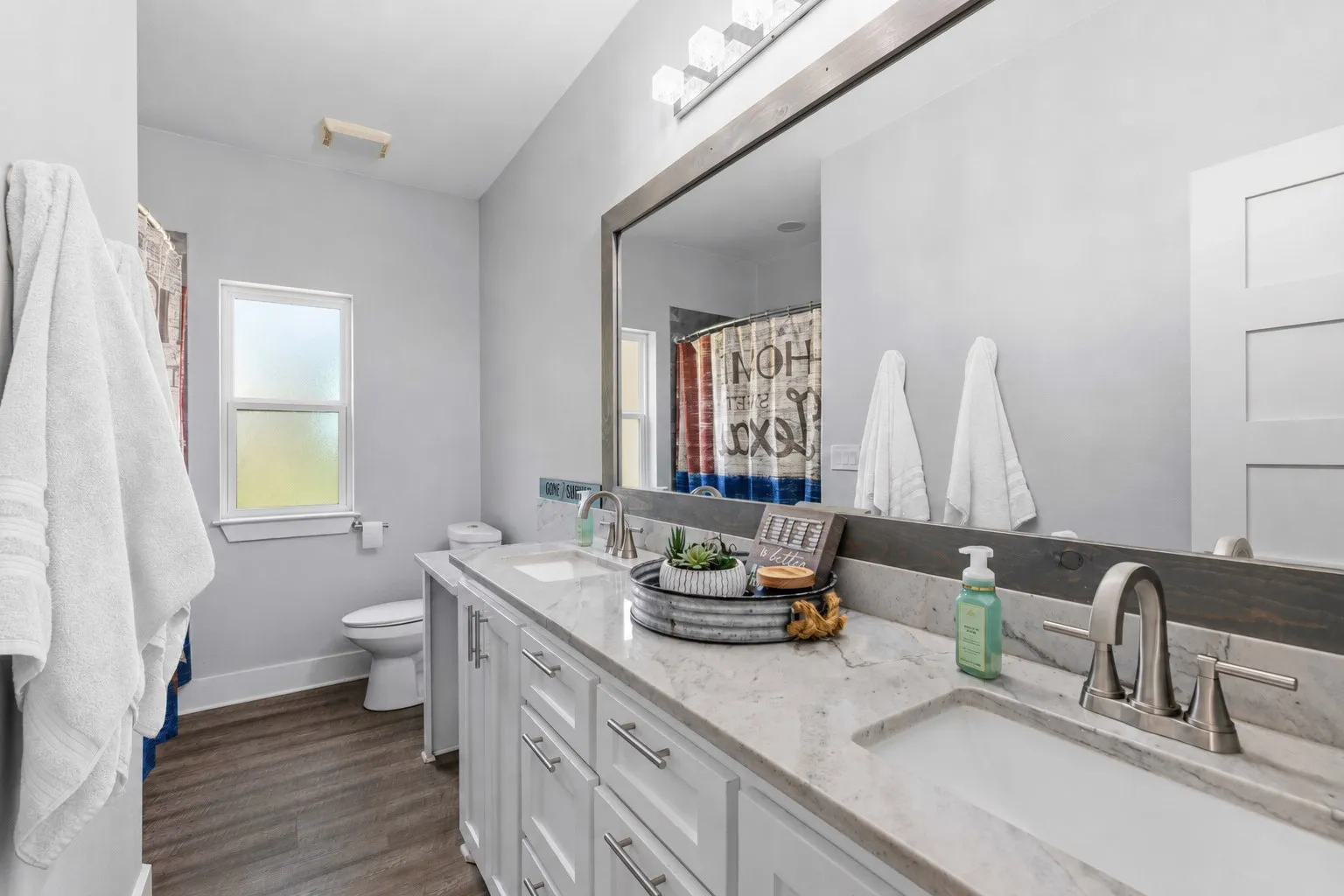 Bathroom featuring an extended double vanity with undermount sinks, stone countertops, and brushed nickel fixtures