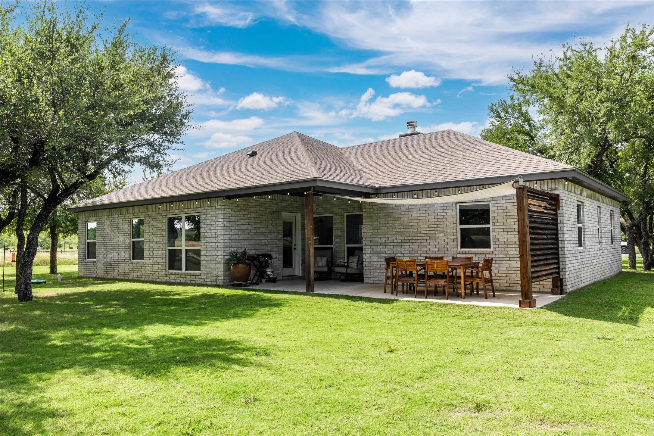 Expansive backyard featuring a manicured lawn and mature trees