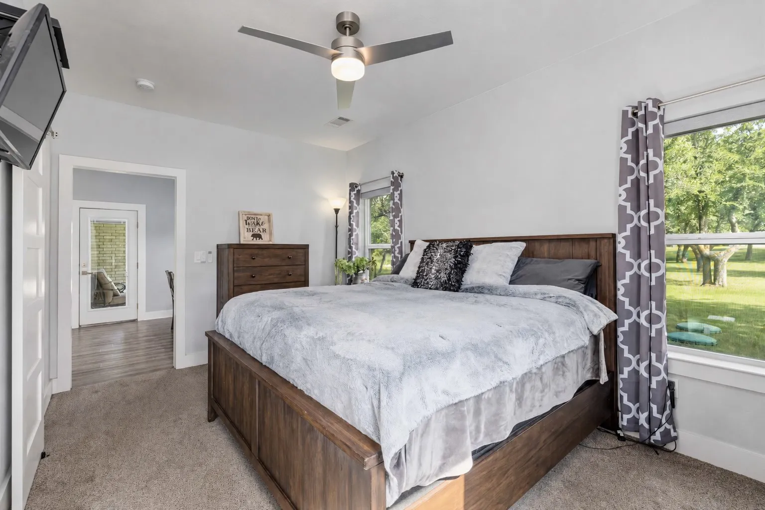Bedroom featuring carpet flooring, a ceiling fan with integrated lighting, and light gray wall paint
