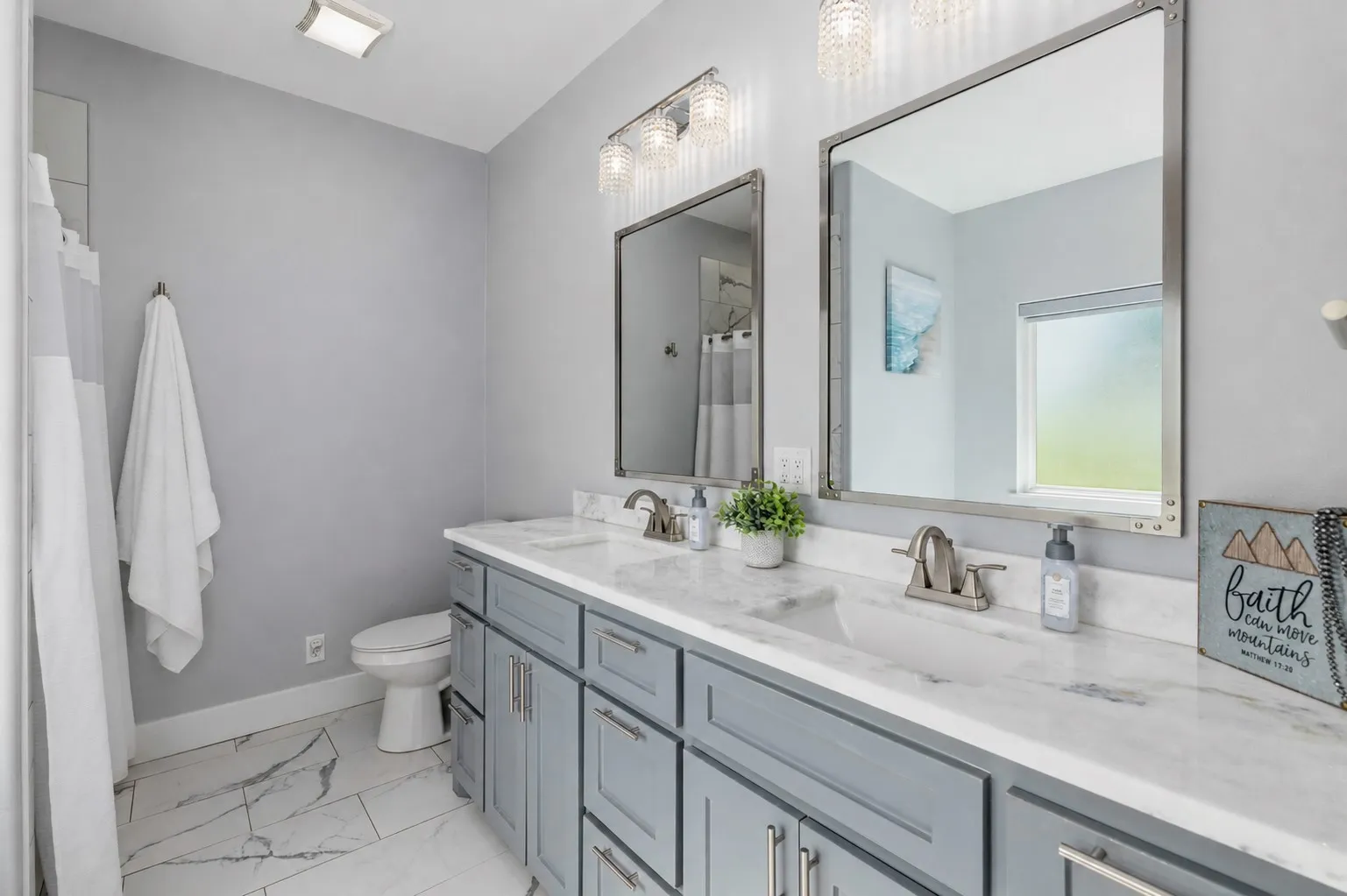 Bathroom featuring a dual vanity with light gray cabinetry and white countertops