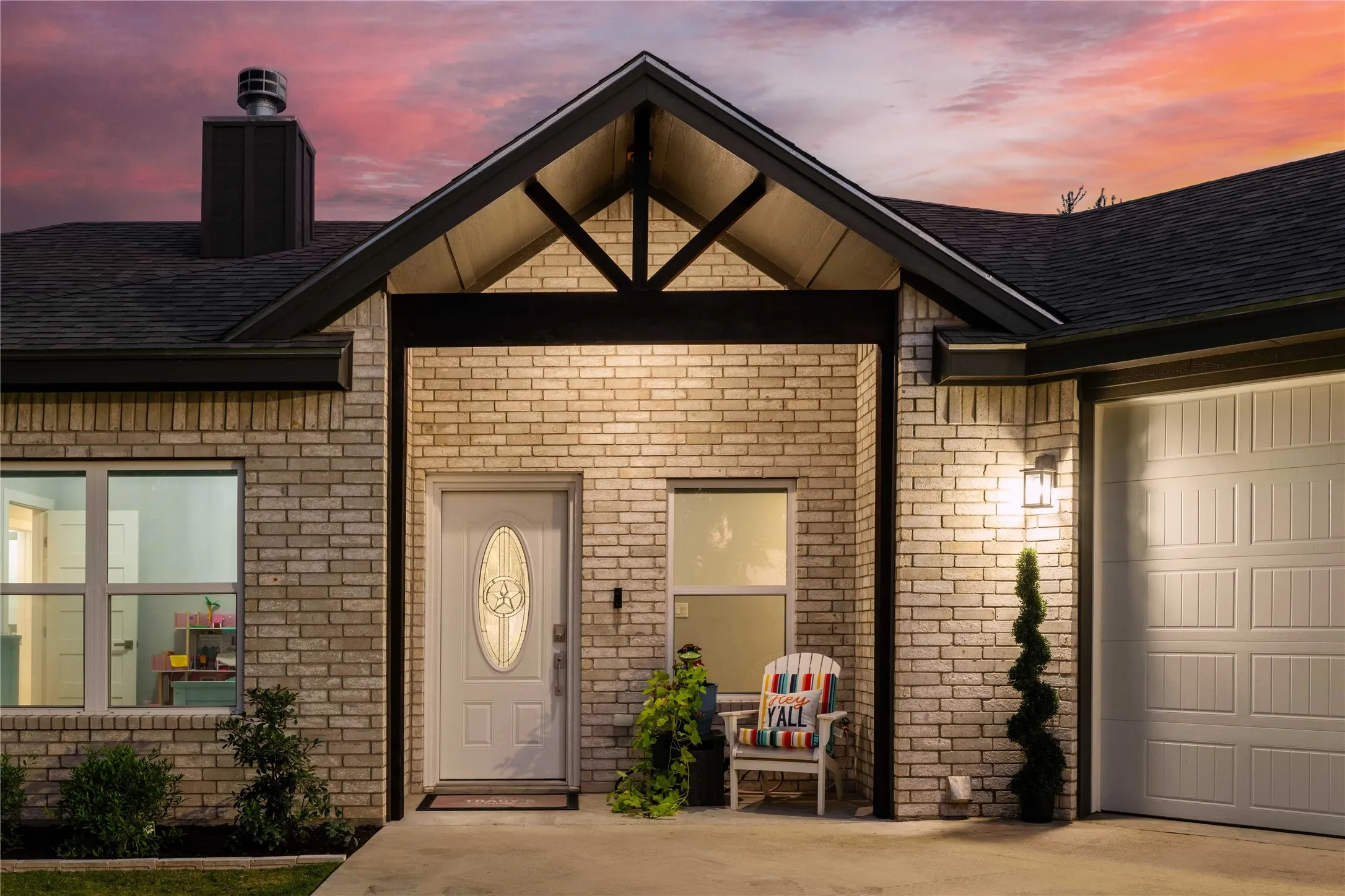 Brick exterior with a prominent gabled entry, asphalt shingle roof, and a single-car garage