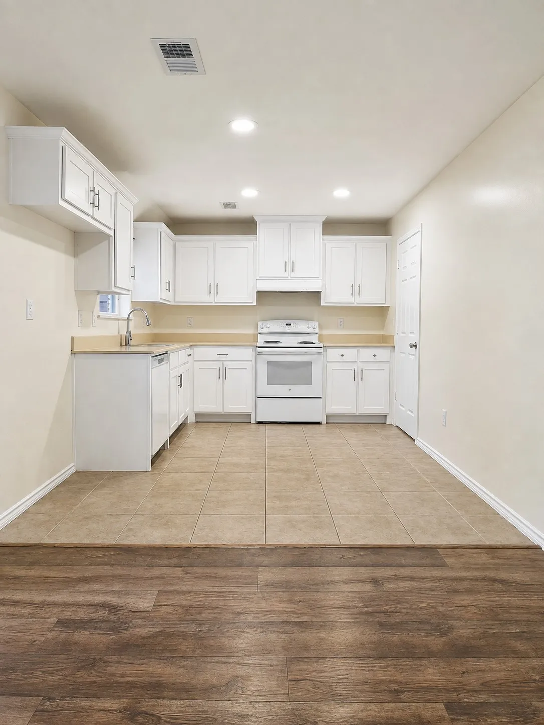 White cabinetry with modern hardware, recessed ceiling lighting, tile flooring, wood-finish flooring, and a built-in range
