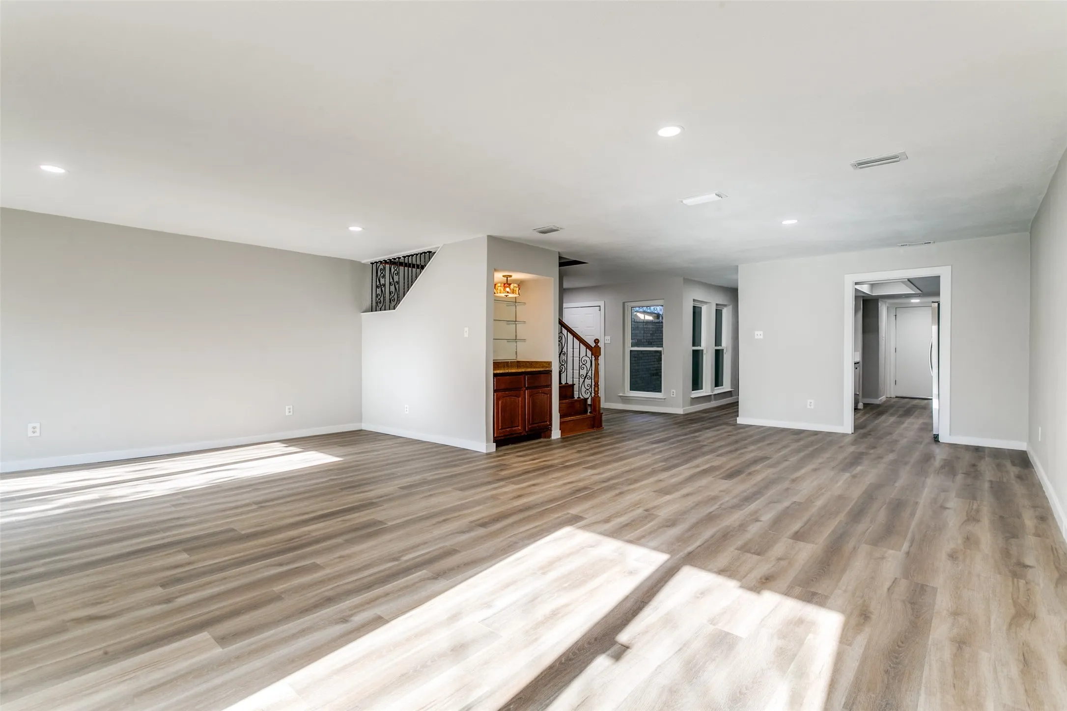 Spacious living area featuring light wood-finish flooring, recessed lighting, and neutral wall tones