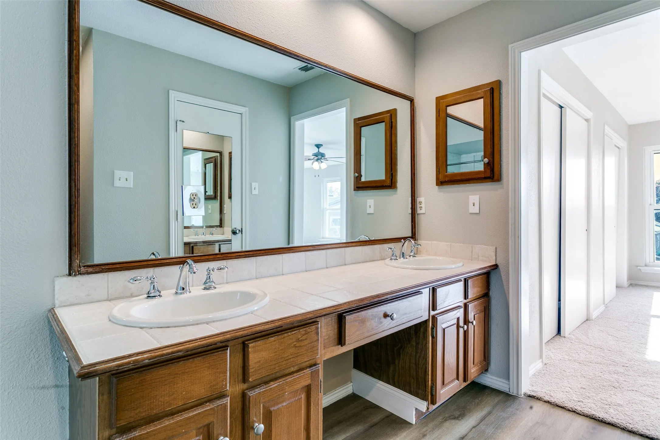Double vanity featuring two undermount sinks, chrome faucets, and a tile countertop
