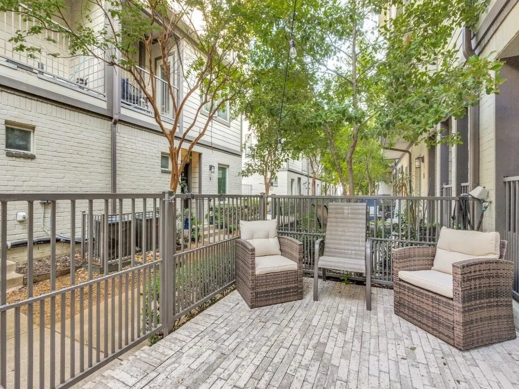 Patio area featuring brick pavers and a metal fence
