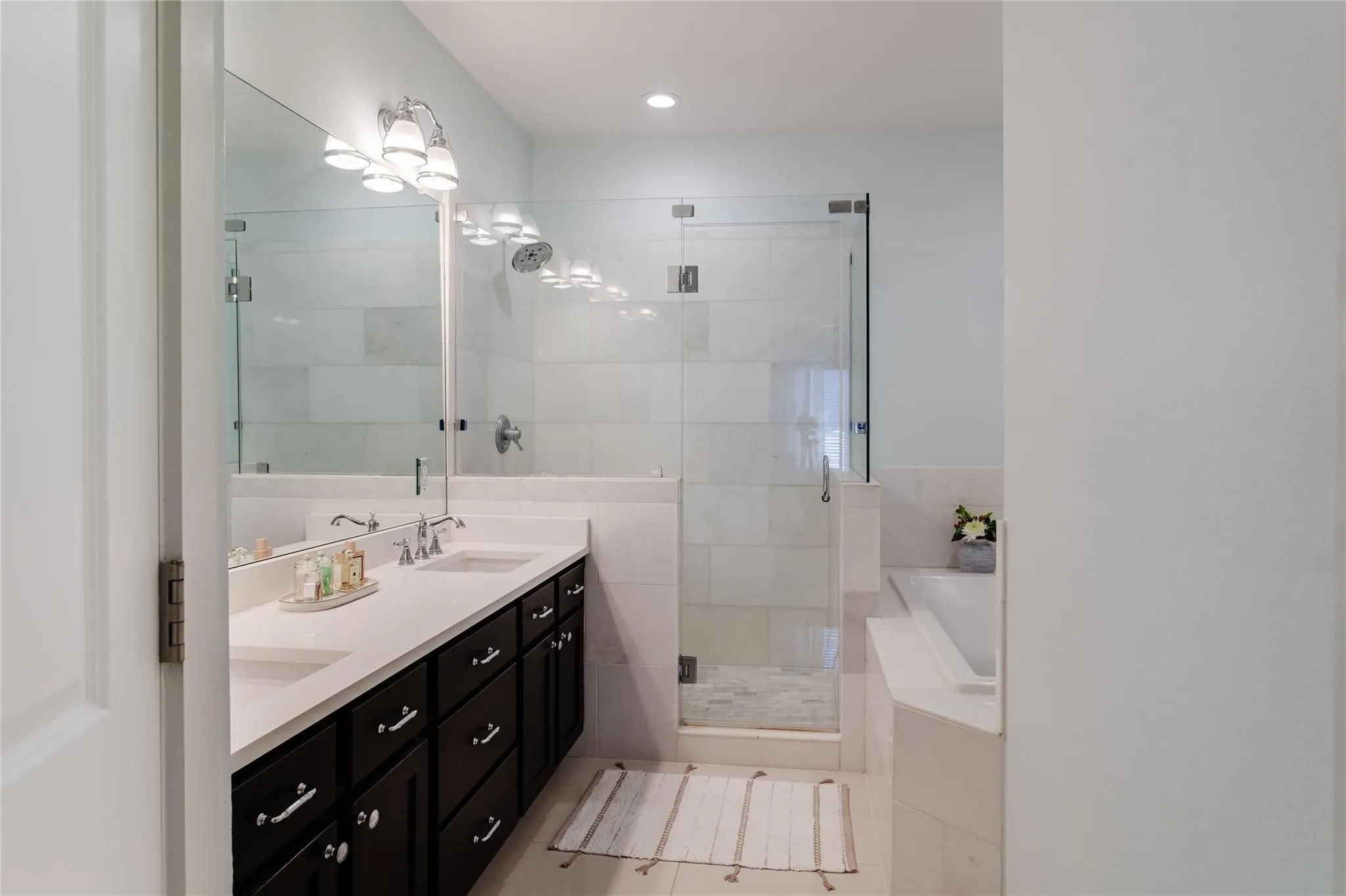 Dual vanity featuring undermount sinks and dark wood cabinetry with chrome hardware