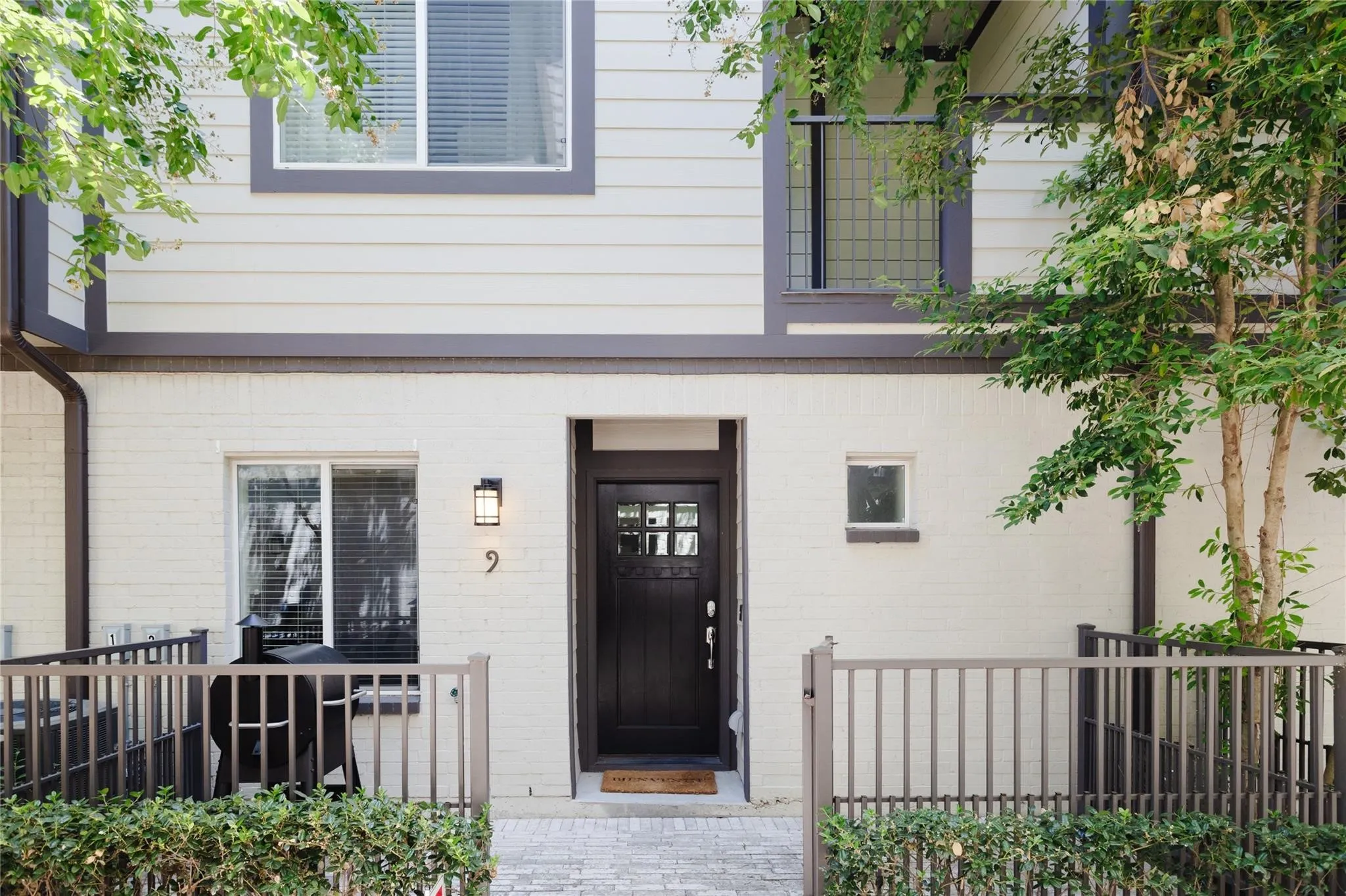 Multi-level facade featuring white brick and horizontal siding