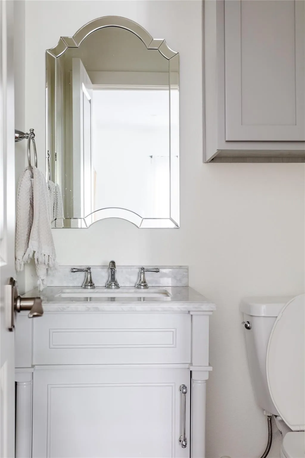 Bathroom vanity featuring a polished chrome widespread faucet, undermount sink, and a stone countertop