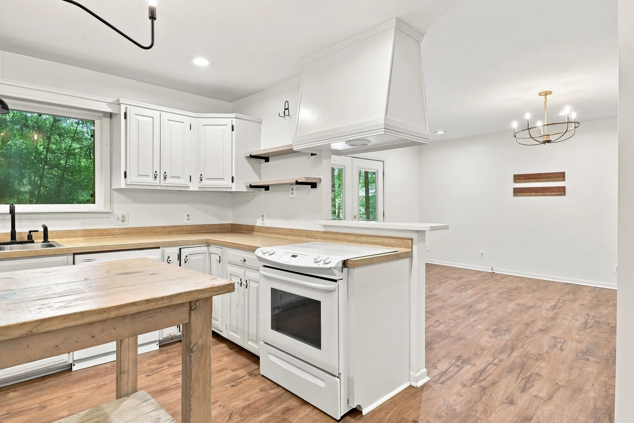 Kitchen featuring white cabinetry, light wood-finish countertops, and wood-finish flooring