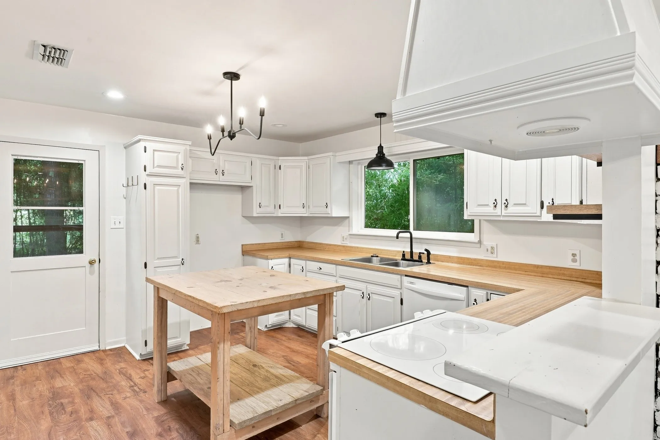 Kitchen featuring white cabinetry, wood-finish countertops, and wood-finish flooring