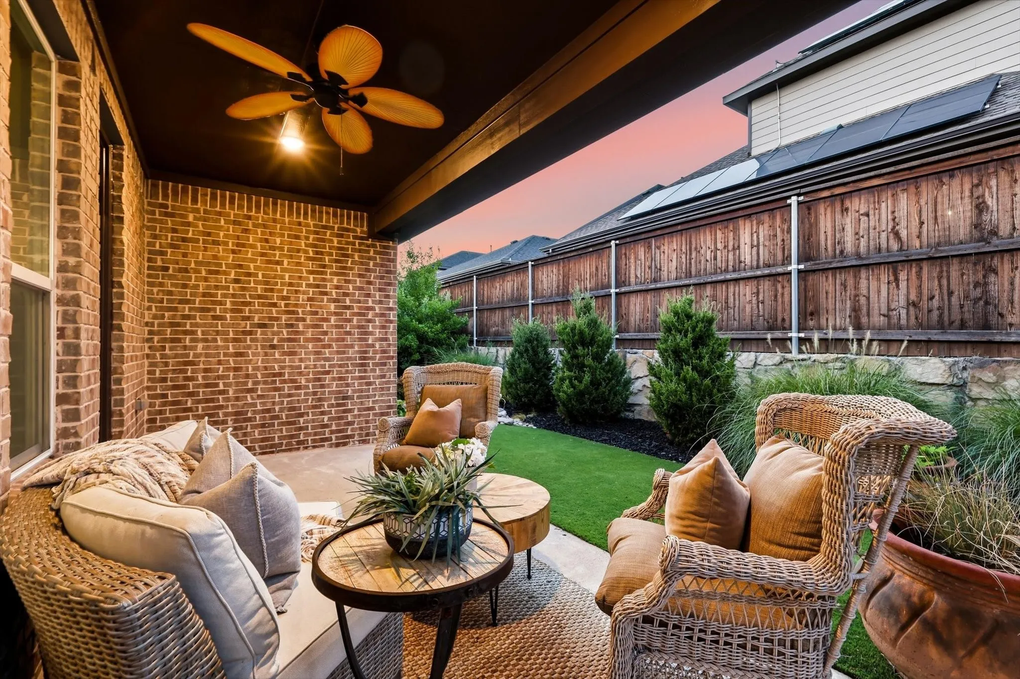 Covered patio with a ceiling fan and recessed lighting, brick exterior, and artificial turf