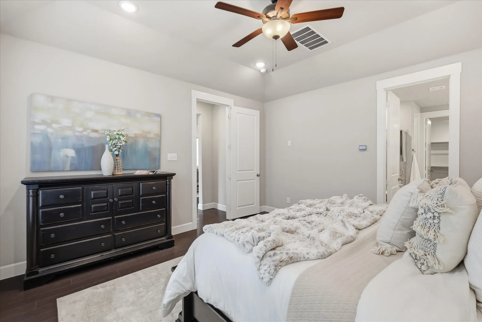 Tray ceiling with recessed lighting, wood-finish flooring, ceiling fan with light fixture, and white trim throughout