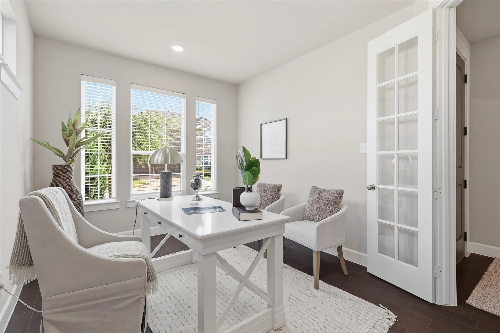 Recessed lighting, dark wood-finish flooring, multiple windows with blinds, white French doors, and light-toned wall finishes