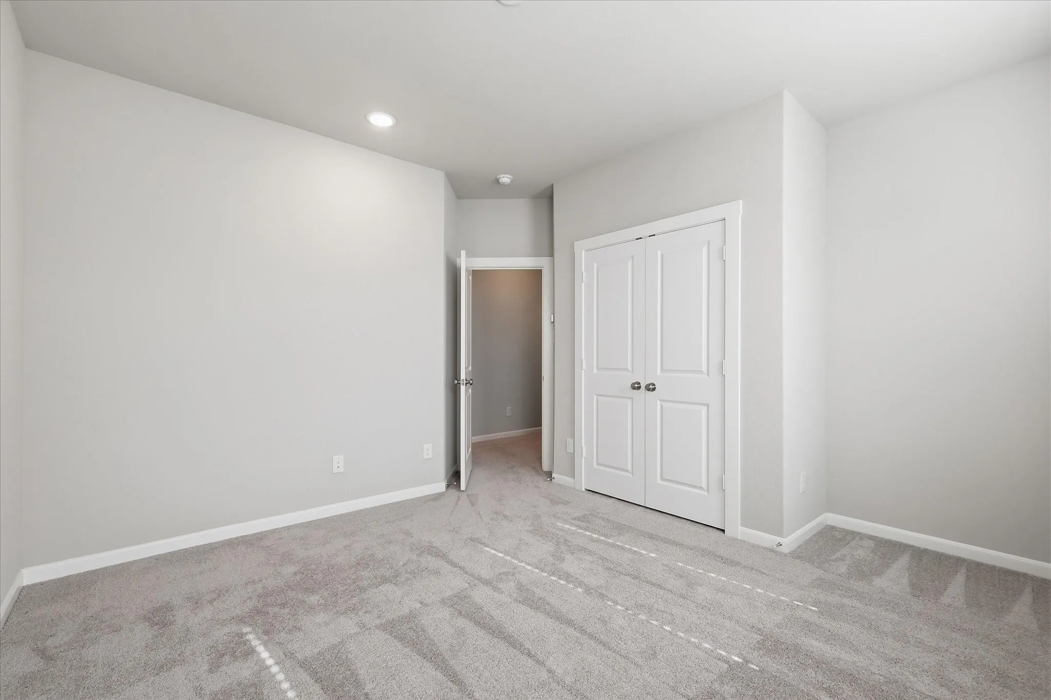 Carpeted flooring, recessed lighting, white interior doors, and neutral wall tones