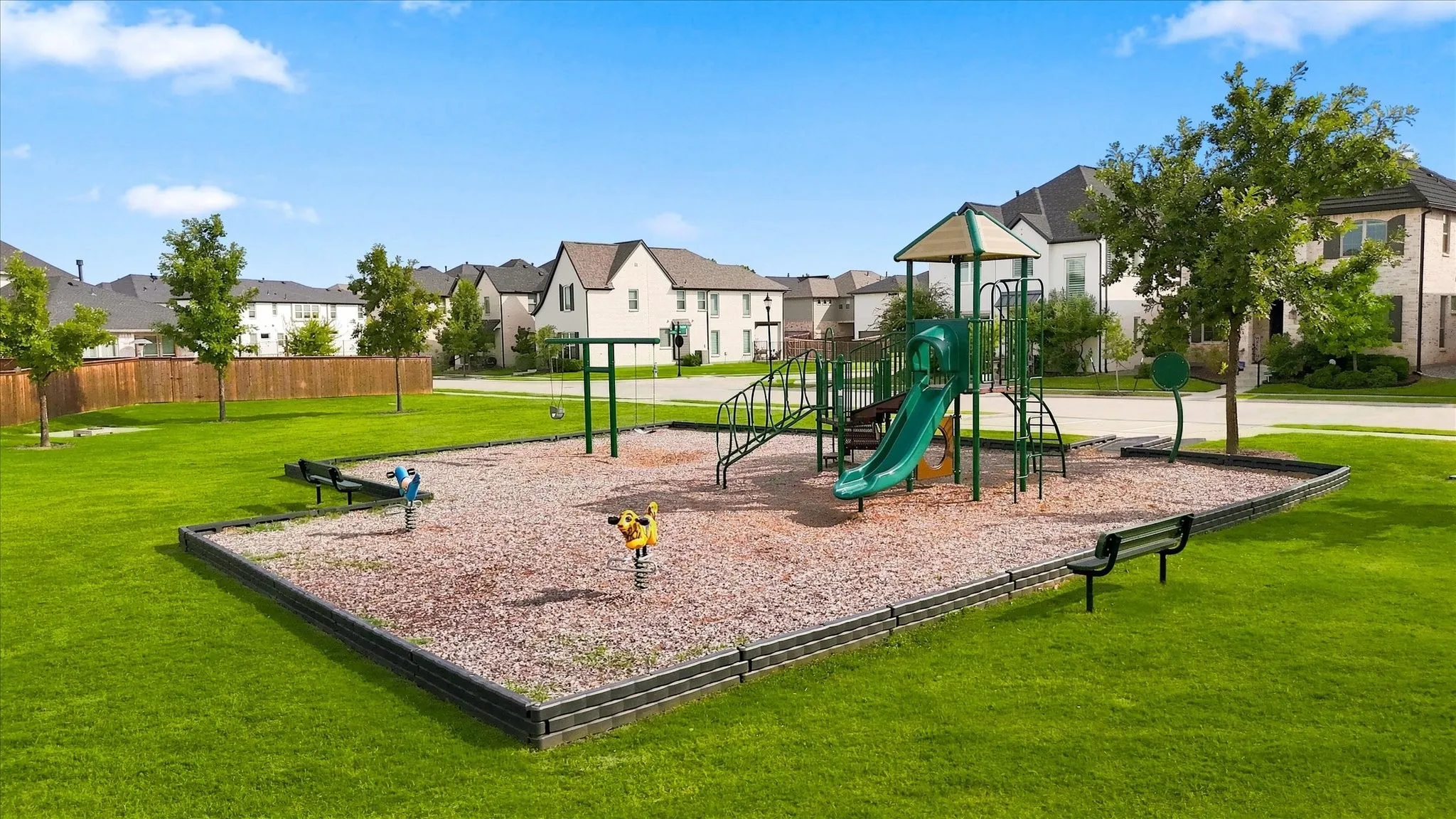 Community playground featuring a slide, swings, and spring riders