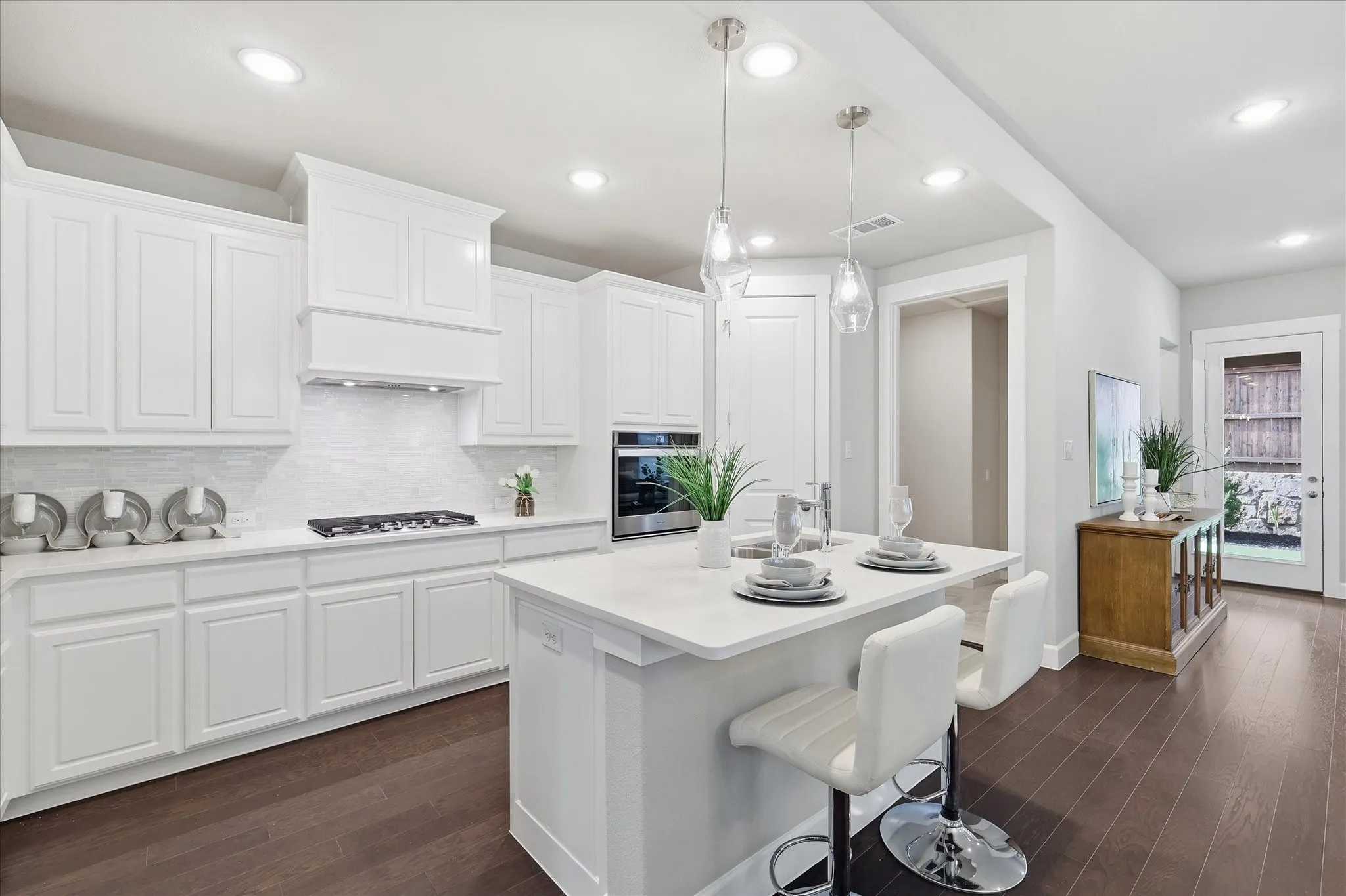 Contemporary kitchen featuring white cabinetry, a large center island, dark wood-finish flooring, a tile backsplash, and recessed lighting