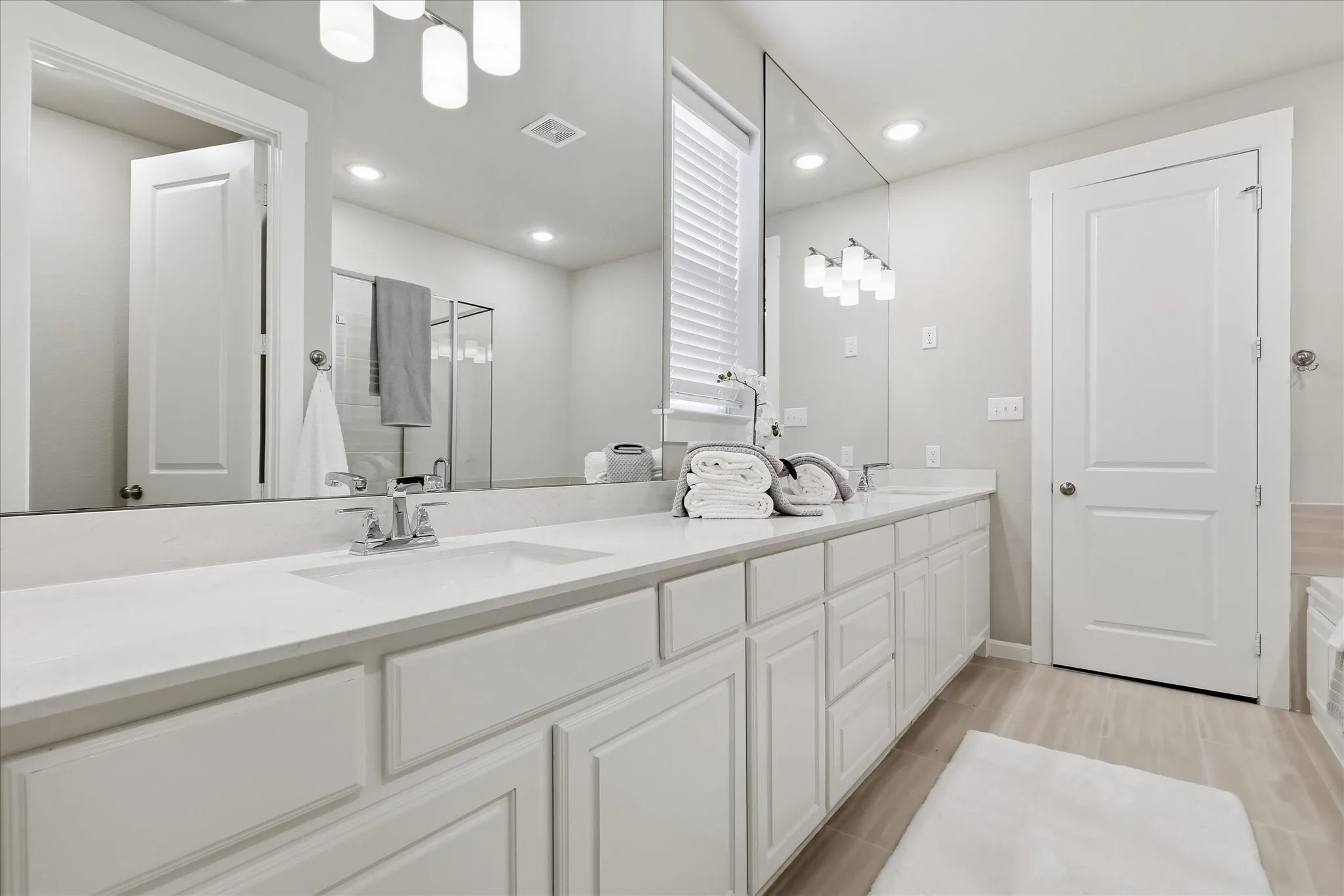 Dual vanity with undermount sinks, chrome fixtures, and light-toned countertops