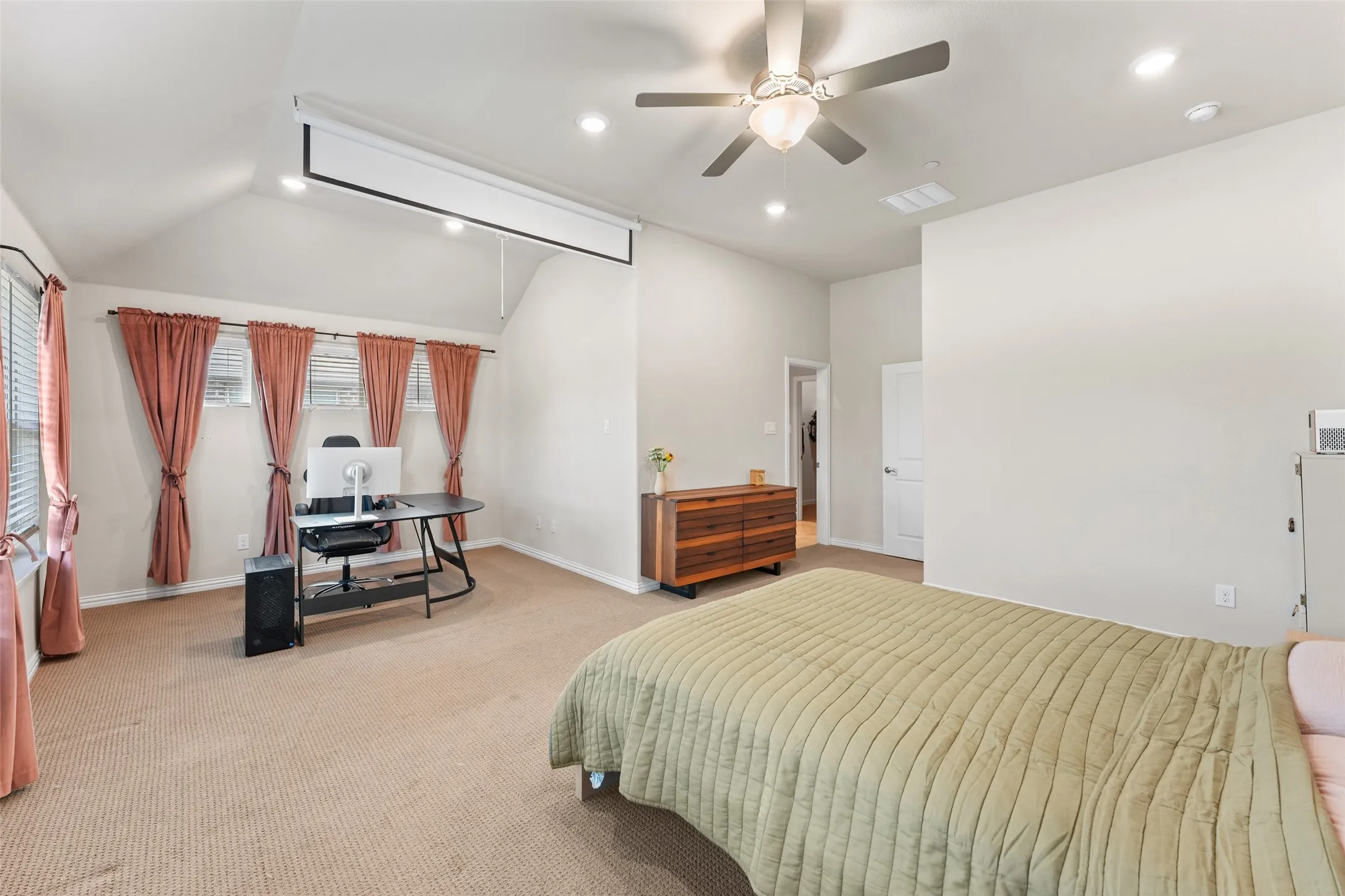 Spacious room featuring vaulted ceilings, recessed lighting, a ceiling fan, and a built-in projector screen