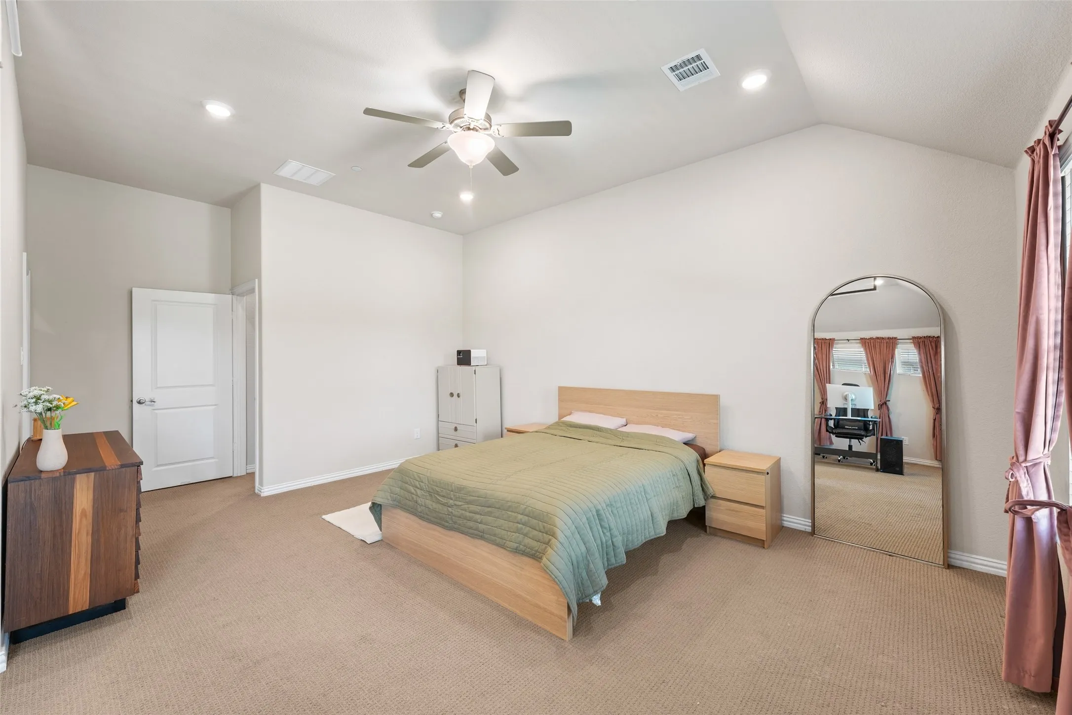 Spacious room featuring vaulted ceilings, recessed lighting, and soft carpet flooring