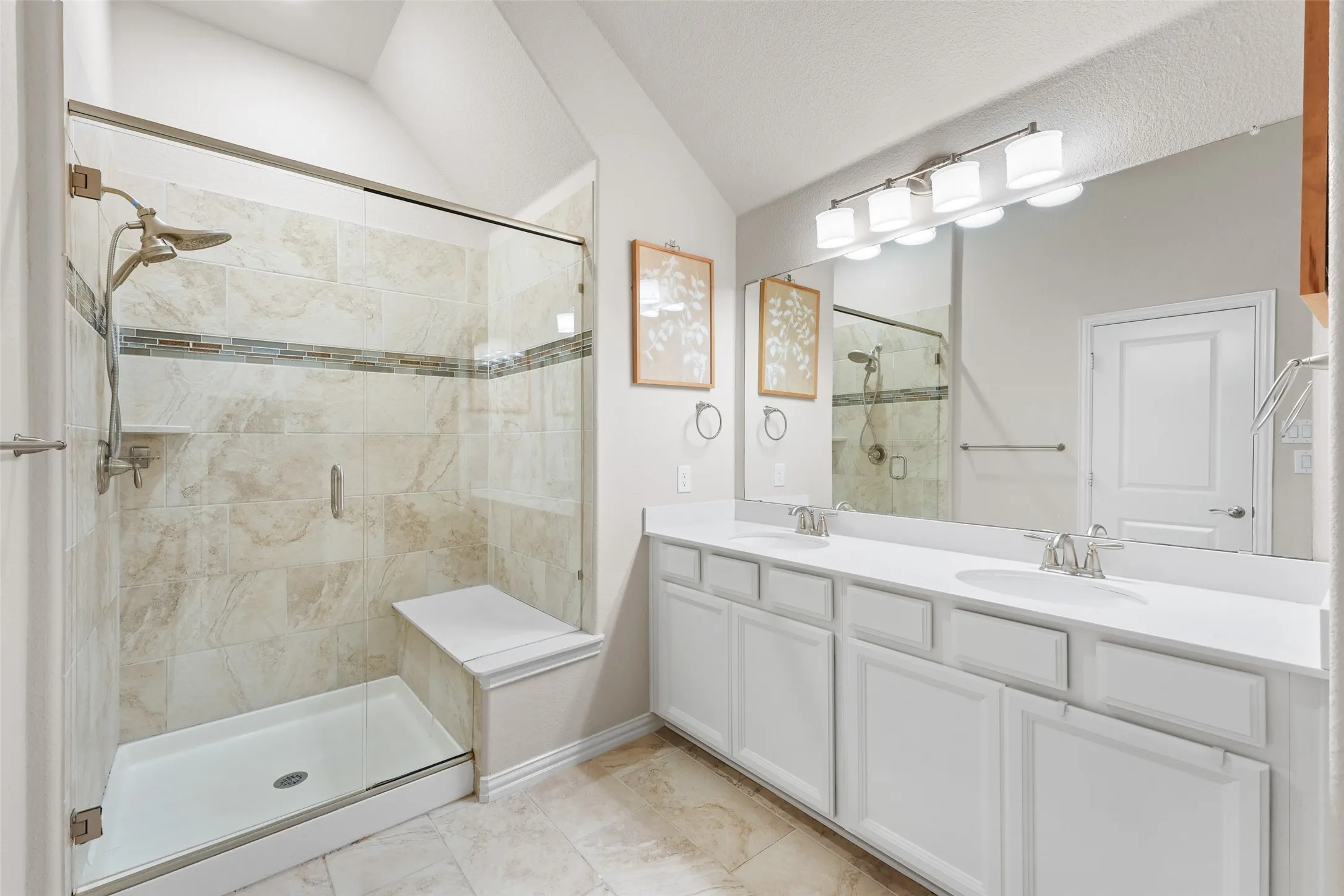 Shower with glass enclosure, integrated bench seating, and dual shower heads