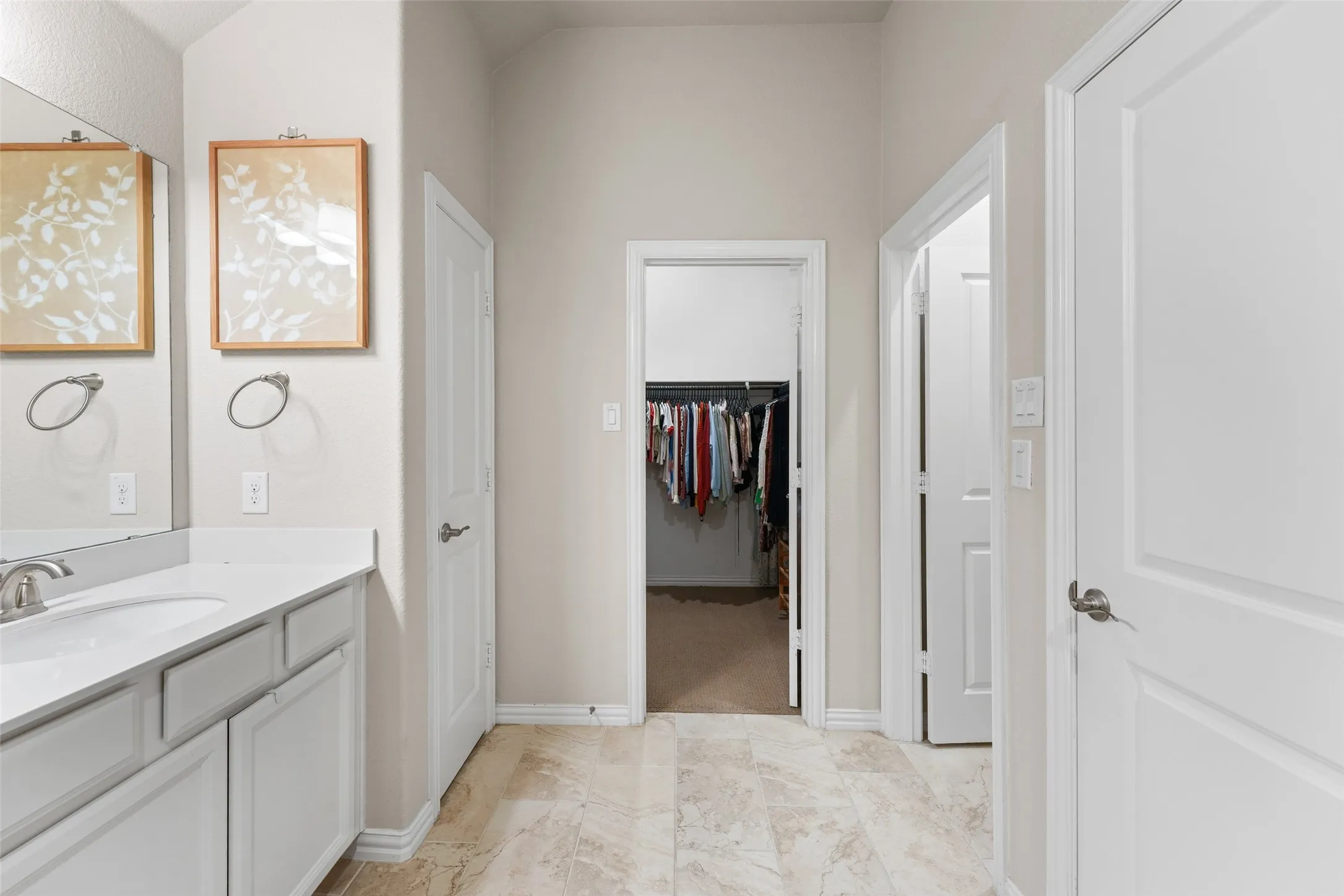 Bathroom vanity featuring white cabinetry, a single basin sink, and a countertop